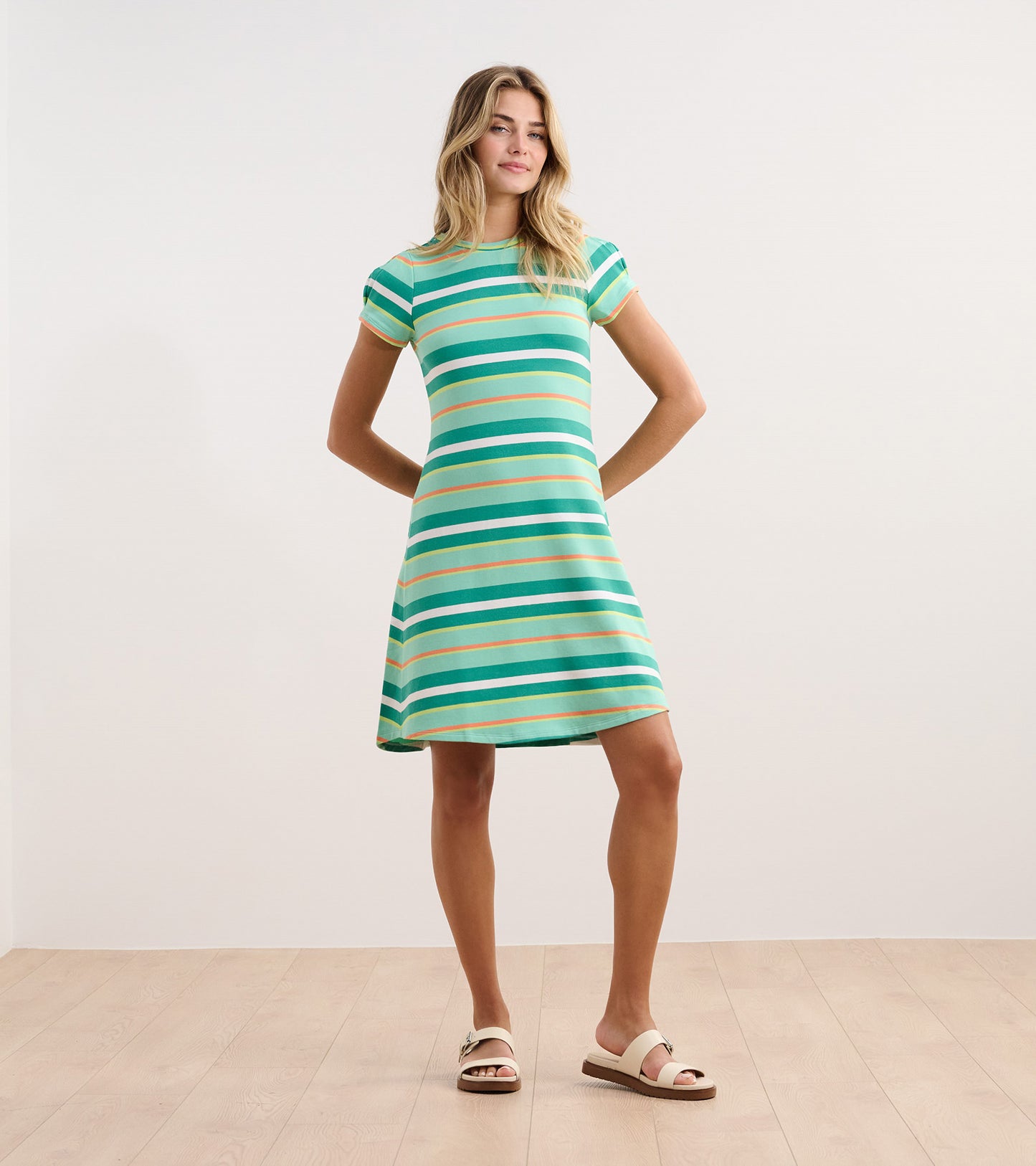 Short-sleeve dress featuring green and blue beveled glass stripes, flared skirt, and a round neckline.