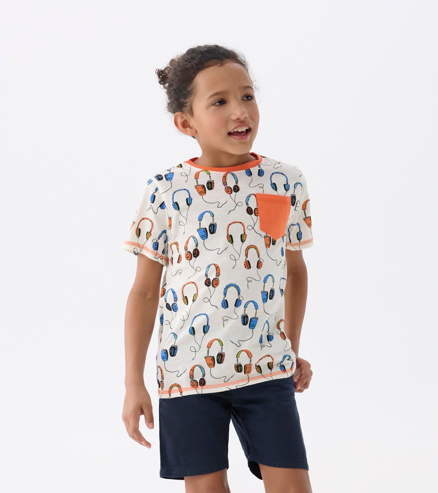 Cream t-shirt featuring a colorful headphone pattern and an orange pocket, suitable for boys aged 2 to 12.