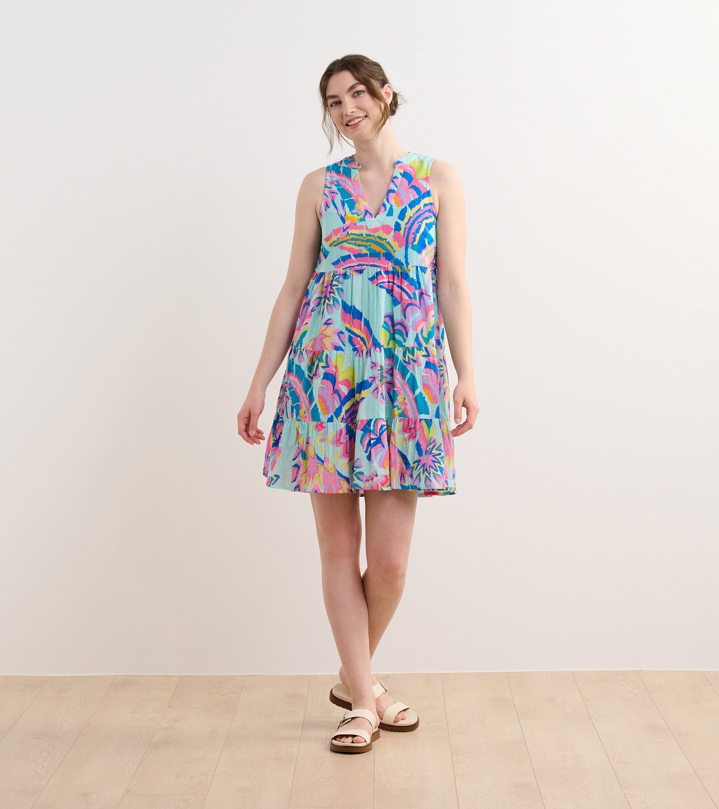 Colorful sleeveless dress featuring a tropical palm print, flared skirt, and a v-neckline, suitable for casual wear.