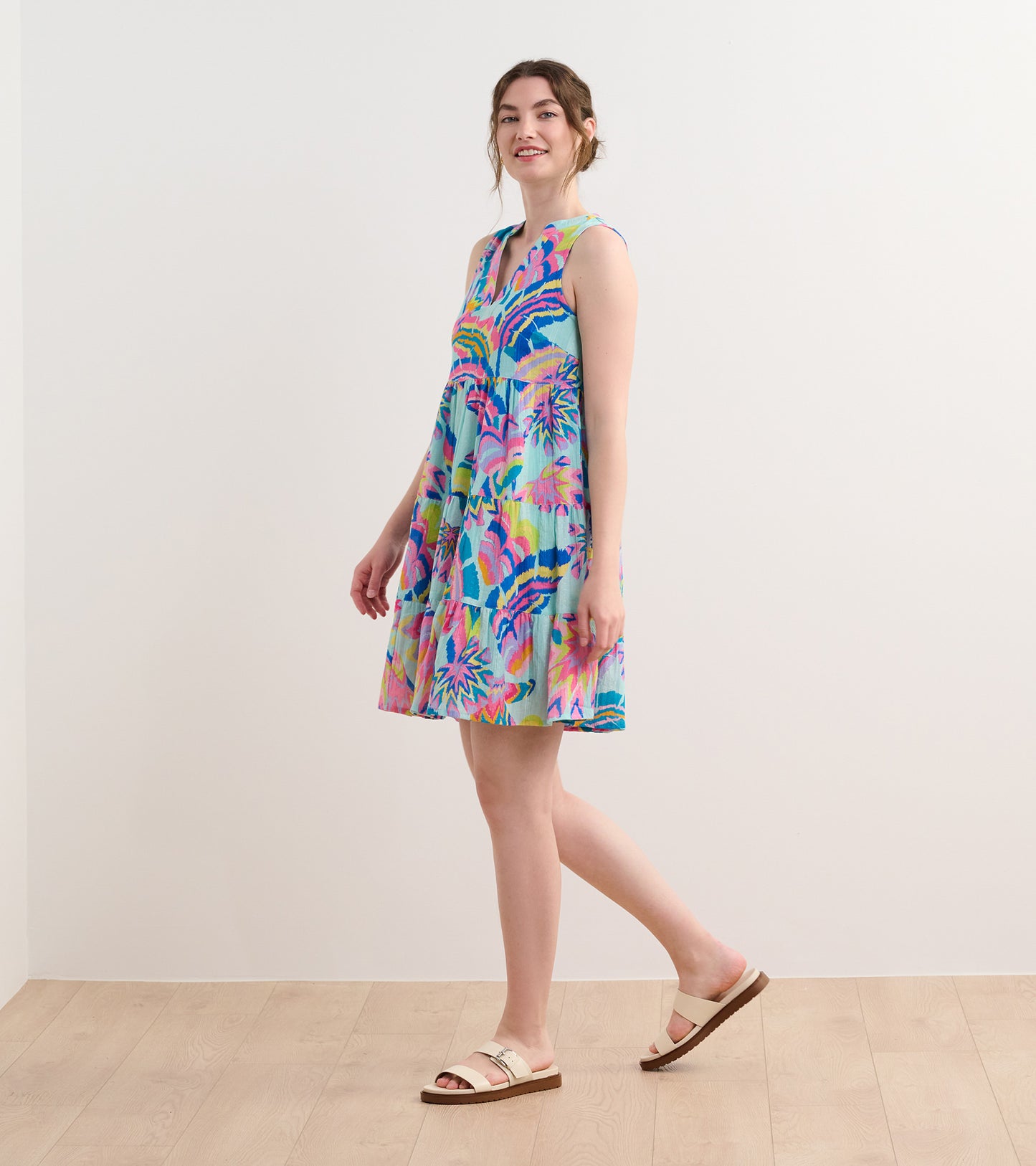 Sleeveless dress in light blue with vibrant palm leaf print, flared silhouette, and knee-length design.