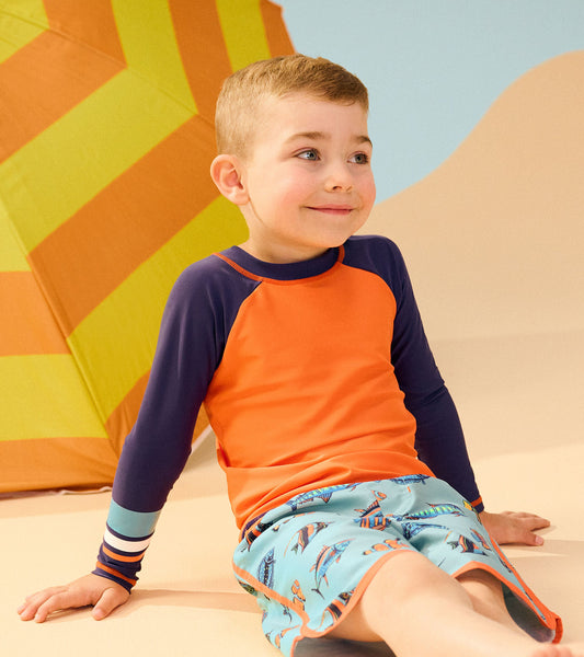Boys' long sleeve rashguard in bright orange with navy sleeves, perfect for beach or pool activities.