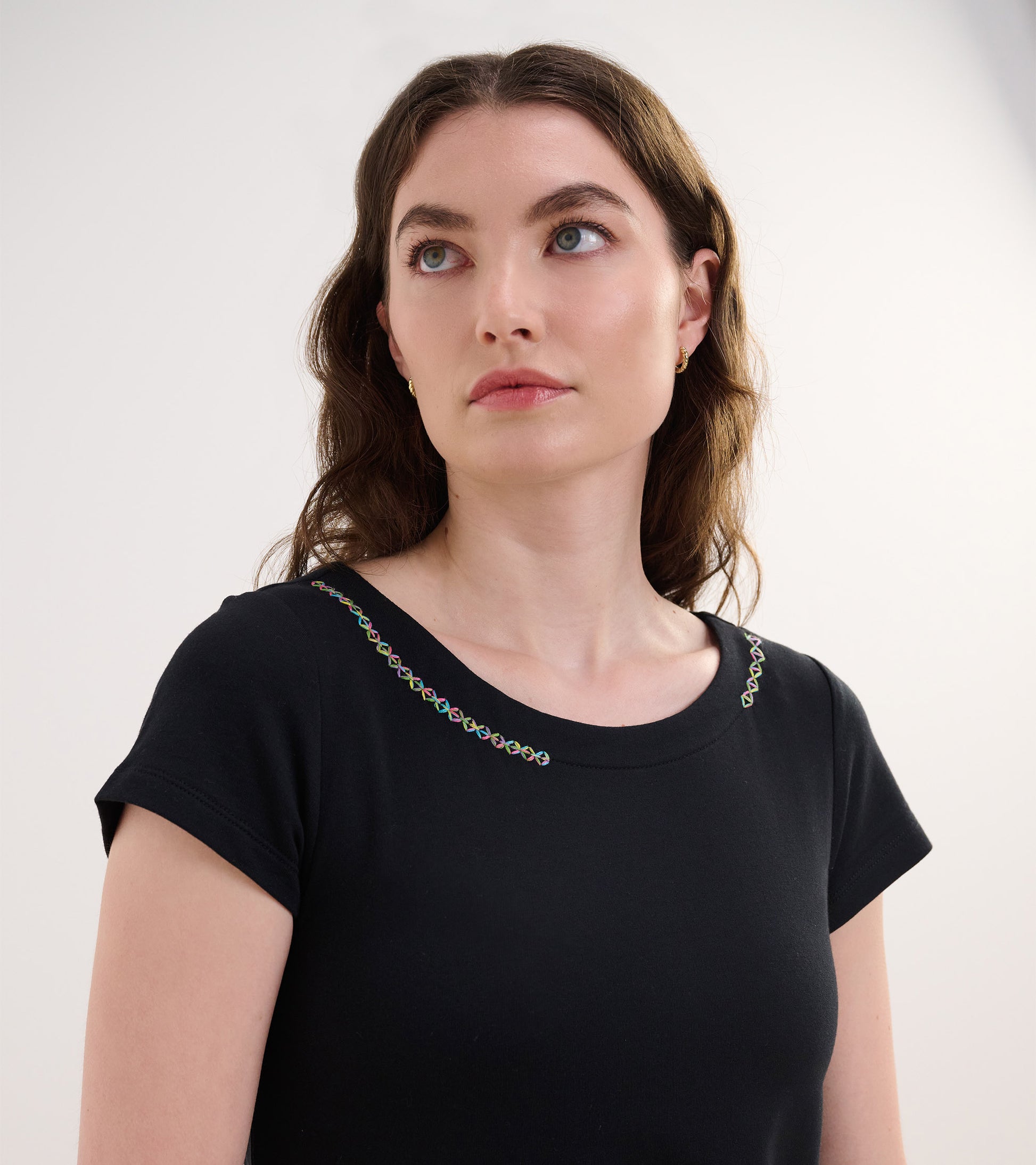 Black French terry dress featuring a round neckline with colorful embroidery along the shoulders.