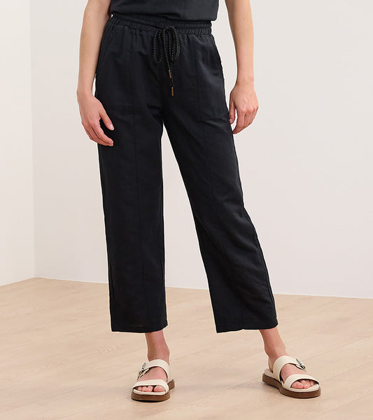 Black straight leg linen pants with an elastic waistband and drawstring, styled with a casual top and sandals.