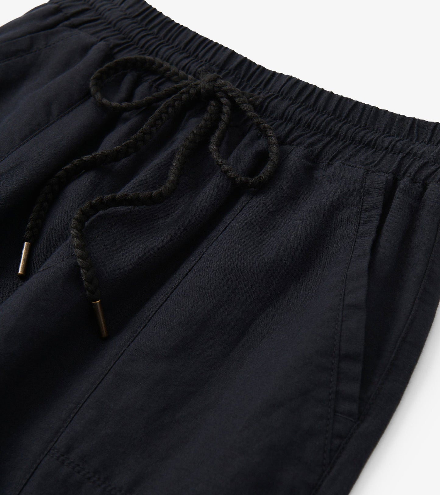 Black straight leg linen pants featuring an elastic waistband and drawstring detail.