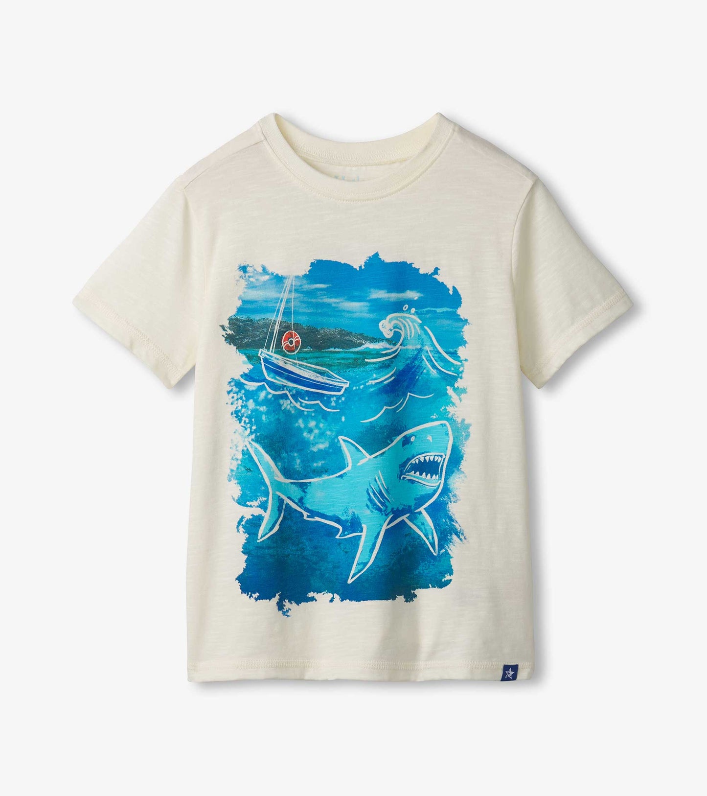 Cream short-sleeve tee featuring a blue shark graphic and a boat on a wave background.