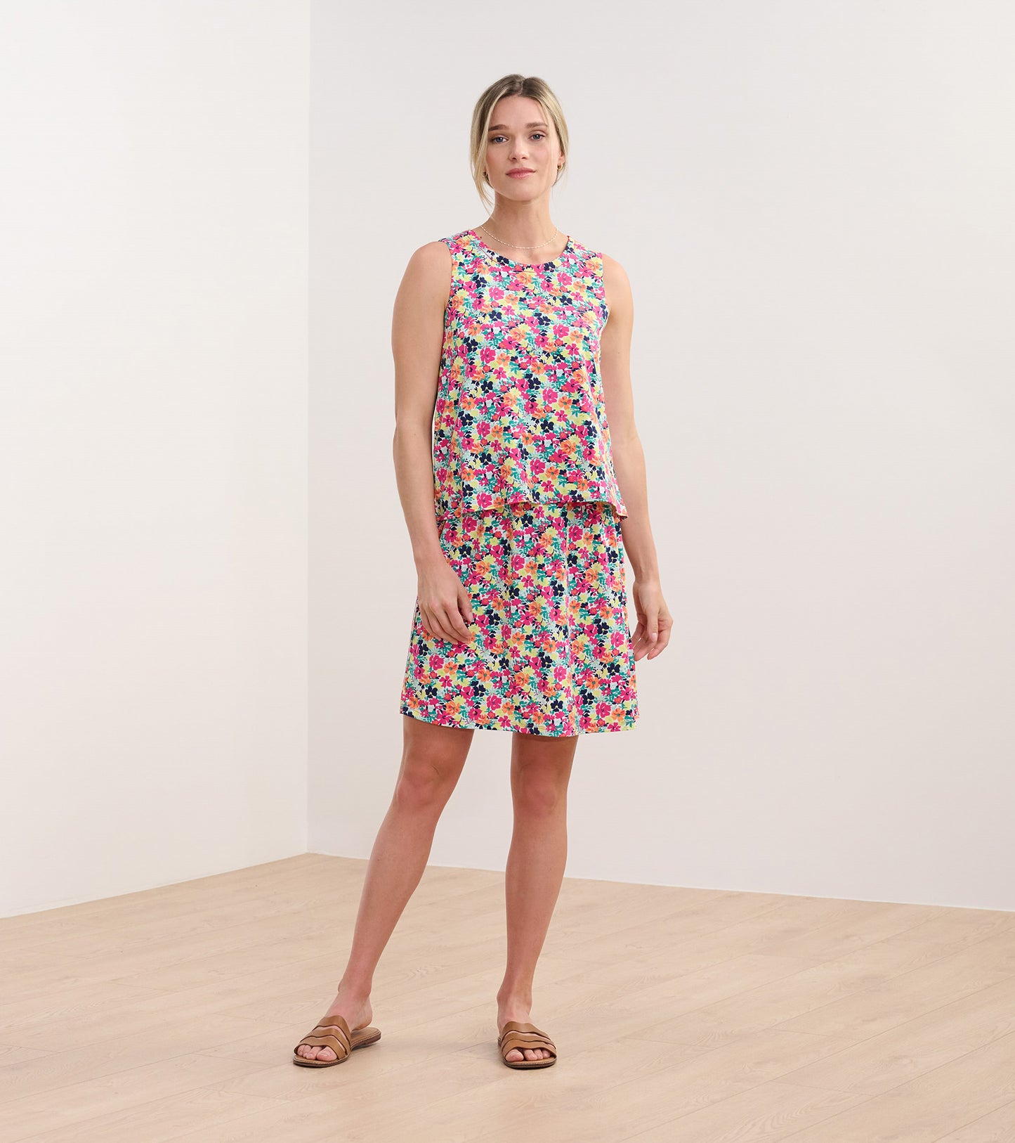 Floral sleeveless dress in pink, blue, and green, featuring a relaxed fit and knee-length skirt.