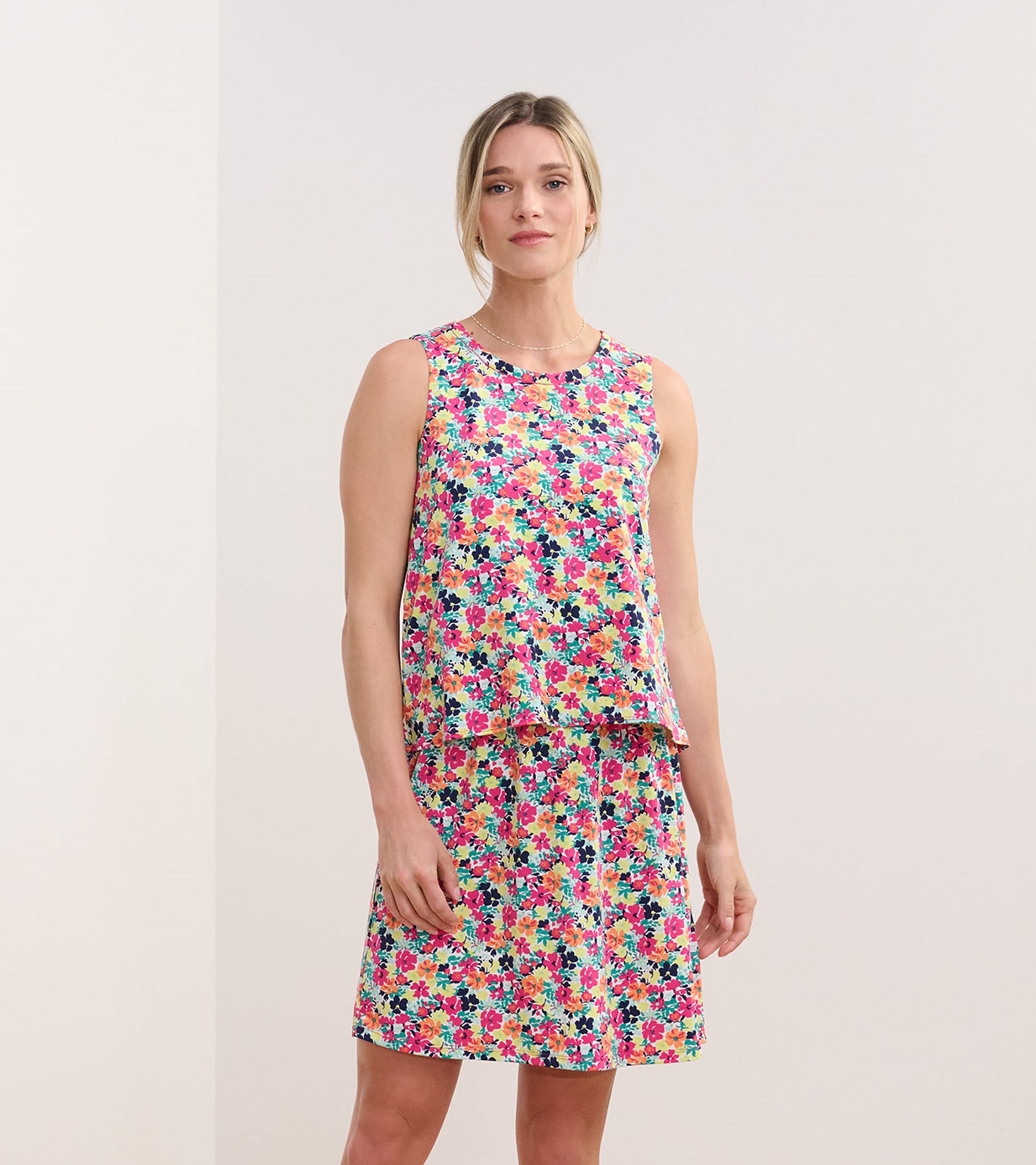 Sleeveless dress featuring a vibrant floral pattern in pink, yellow, and blue, with a relaxed fit and flared skirt.