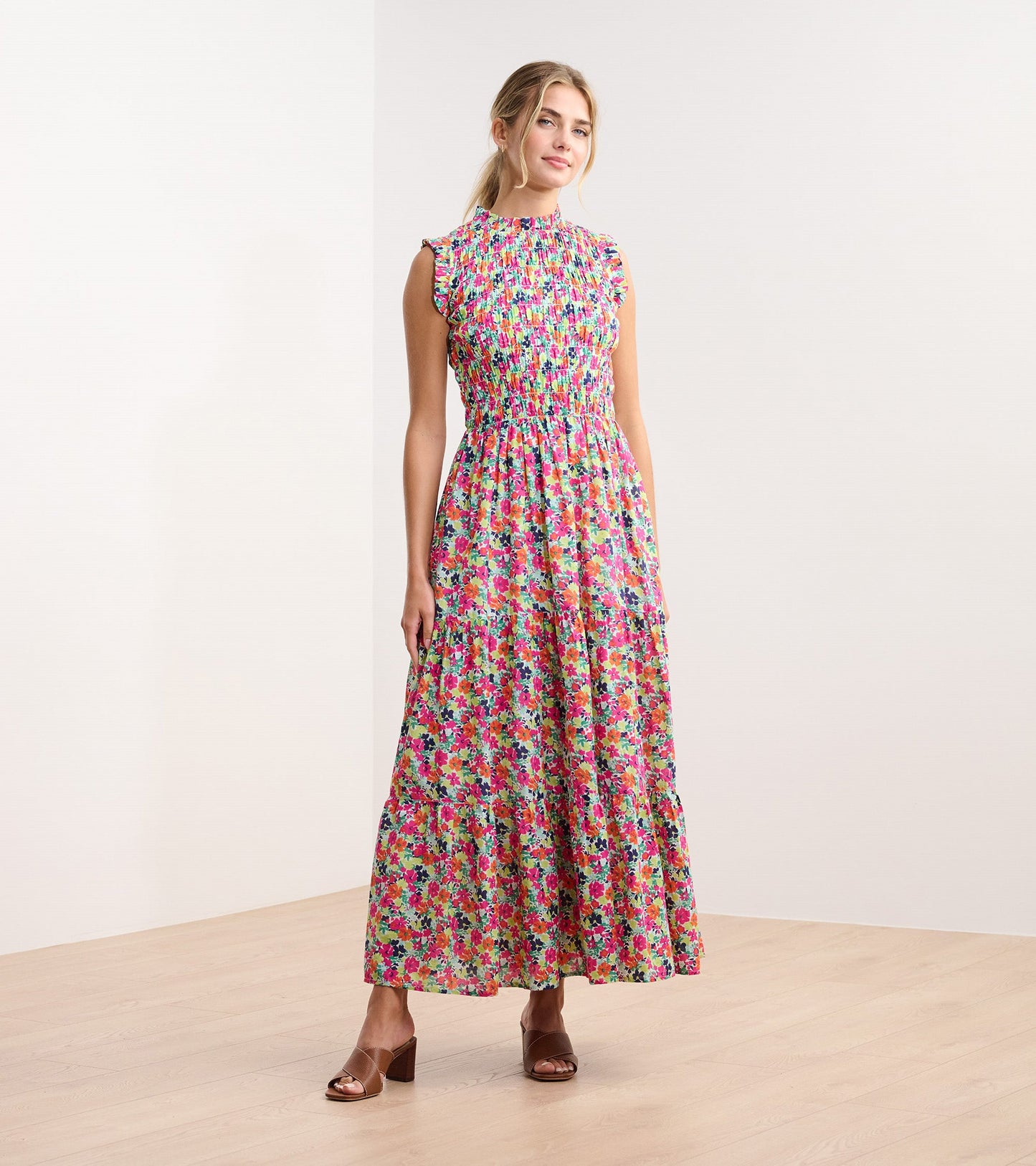 Floral smocked maxi dress with a high neckline and tiered skirt, featuring vibrant pink, green, and blue patterns.