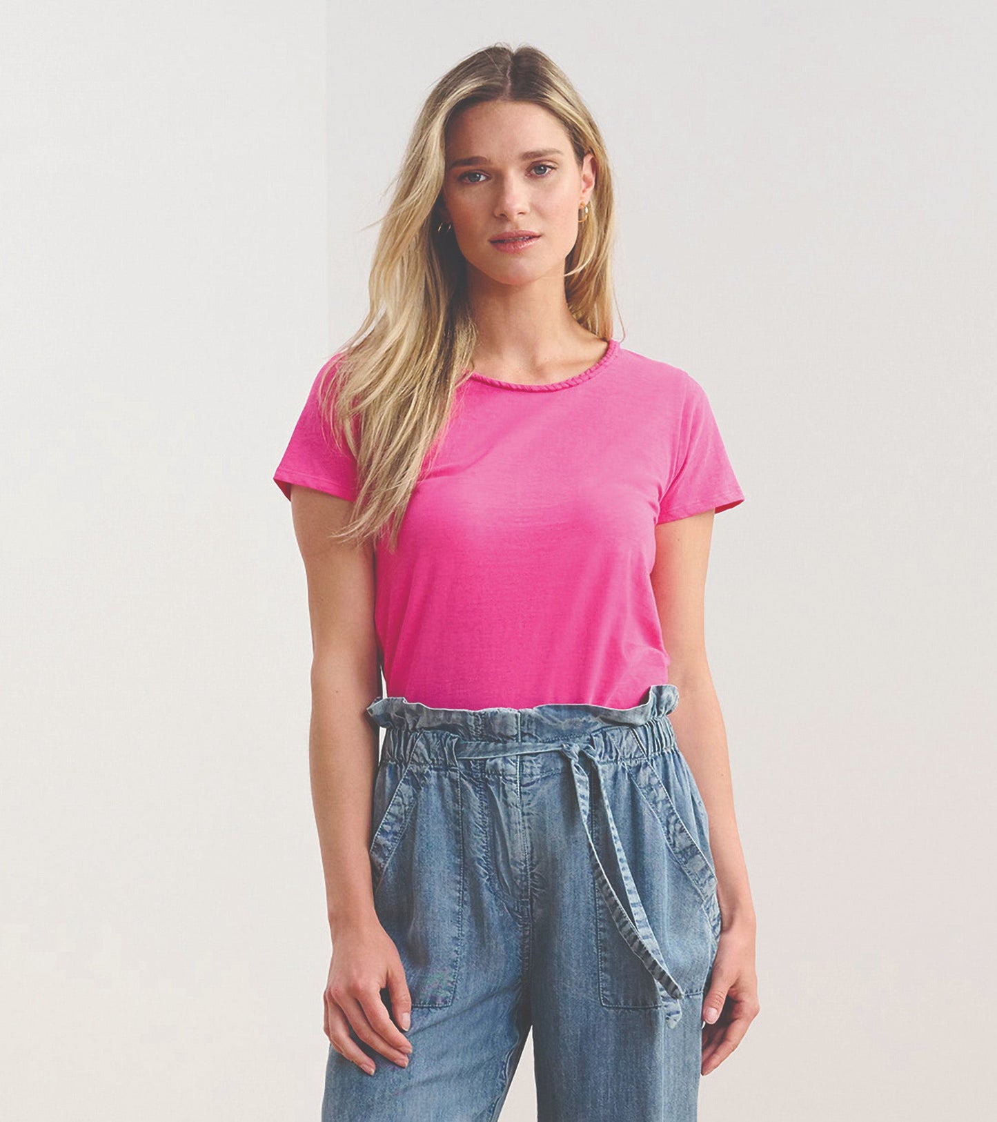 Fuschia braided neck tee in a relaxed fit, paired with light blue denim pants.