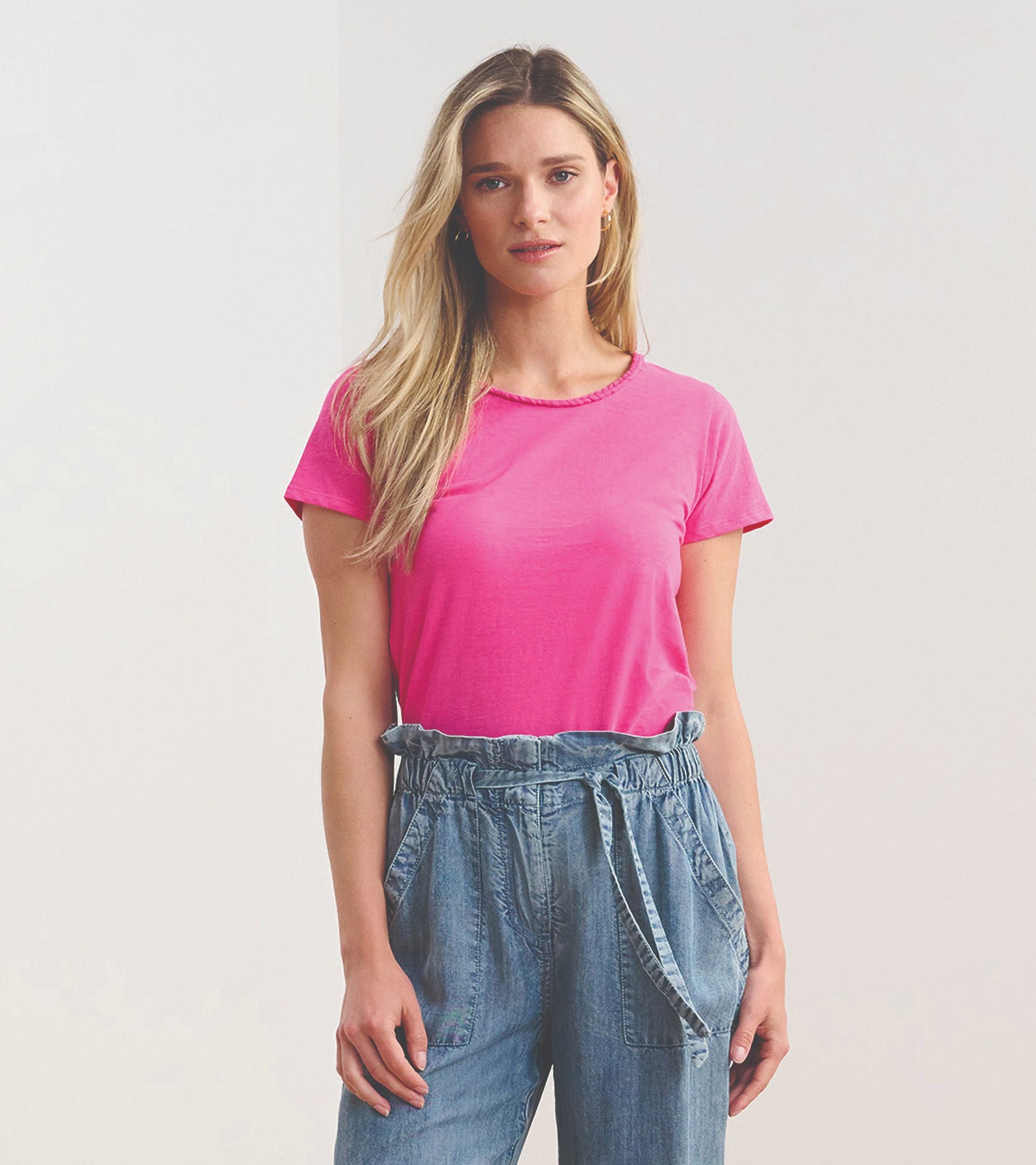 Fuschia braided neck tee in a relaxed fit, paired with light blue denim pants.
