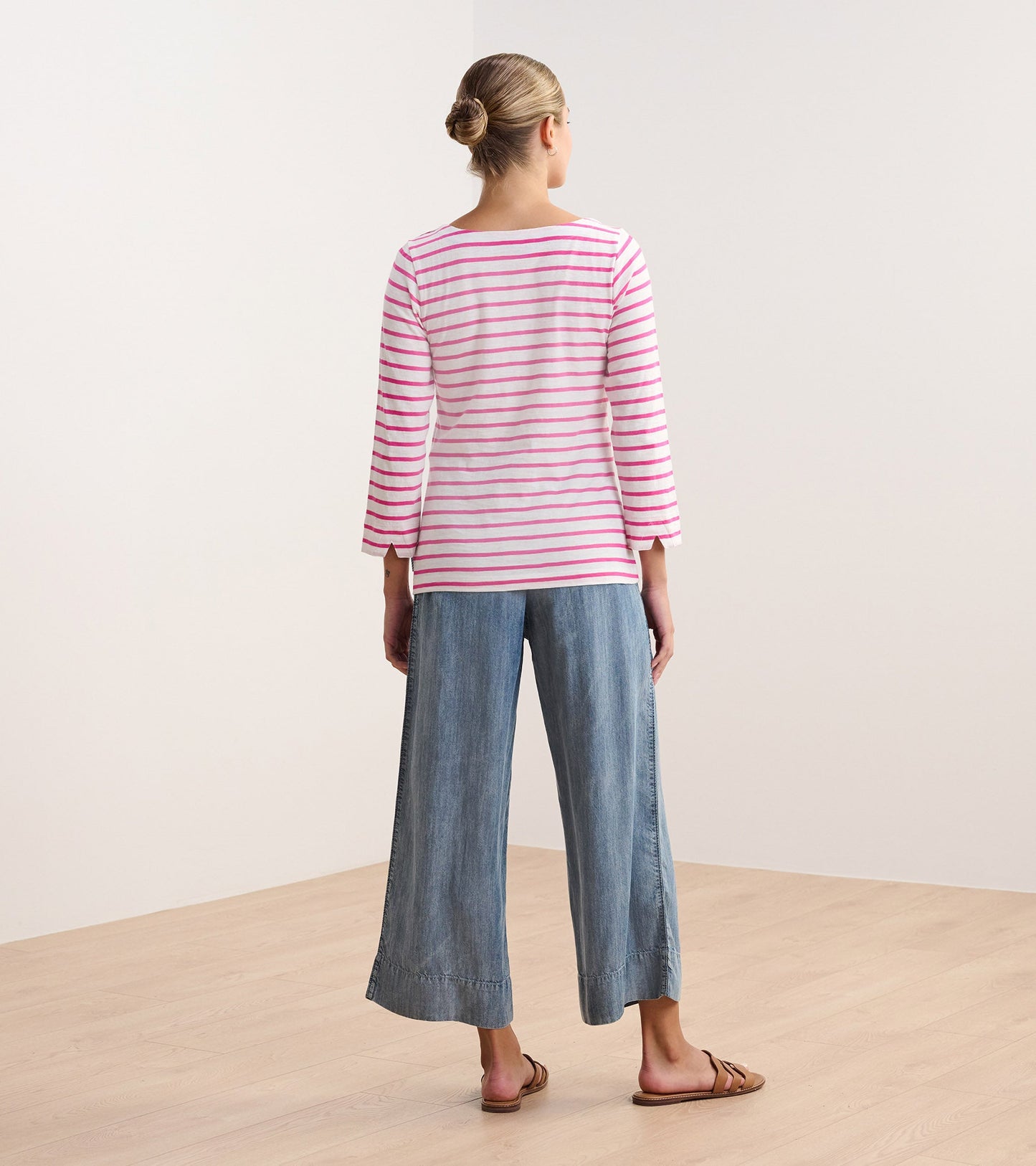 Fuchsia striped long-sleeve top with a relaxed fit, paired with wide-leg denim pants, viewed from the back.