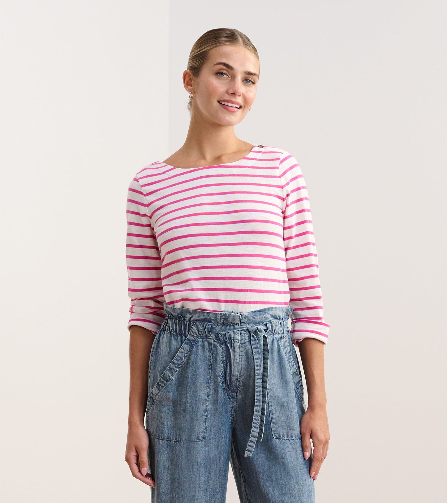 Fuchsia striped long-sleeve top with a boat neckline, paired with light blue denim pants.
