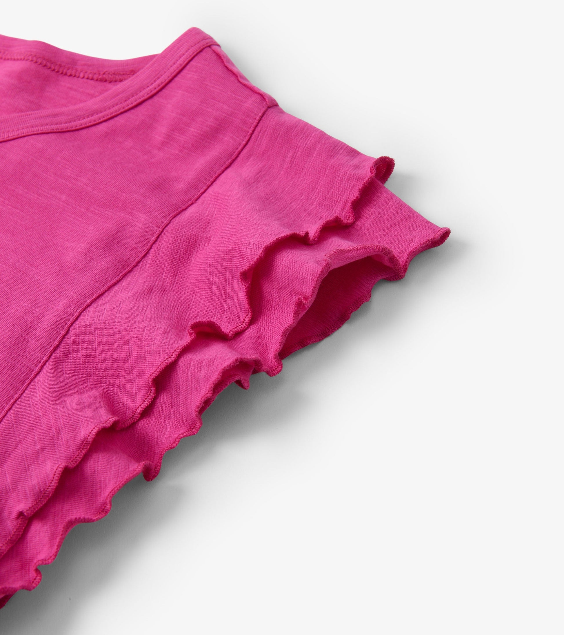 Fuchsia tank top featuring layered ruffle sleeves and a soft, lightweight fabric.
