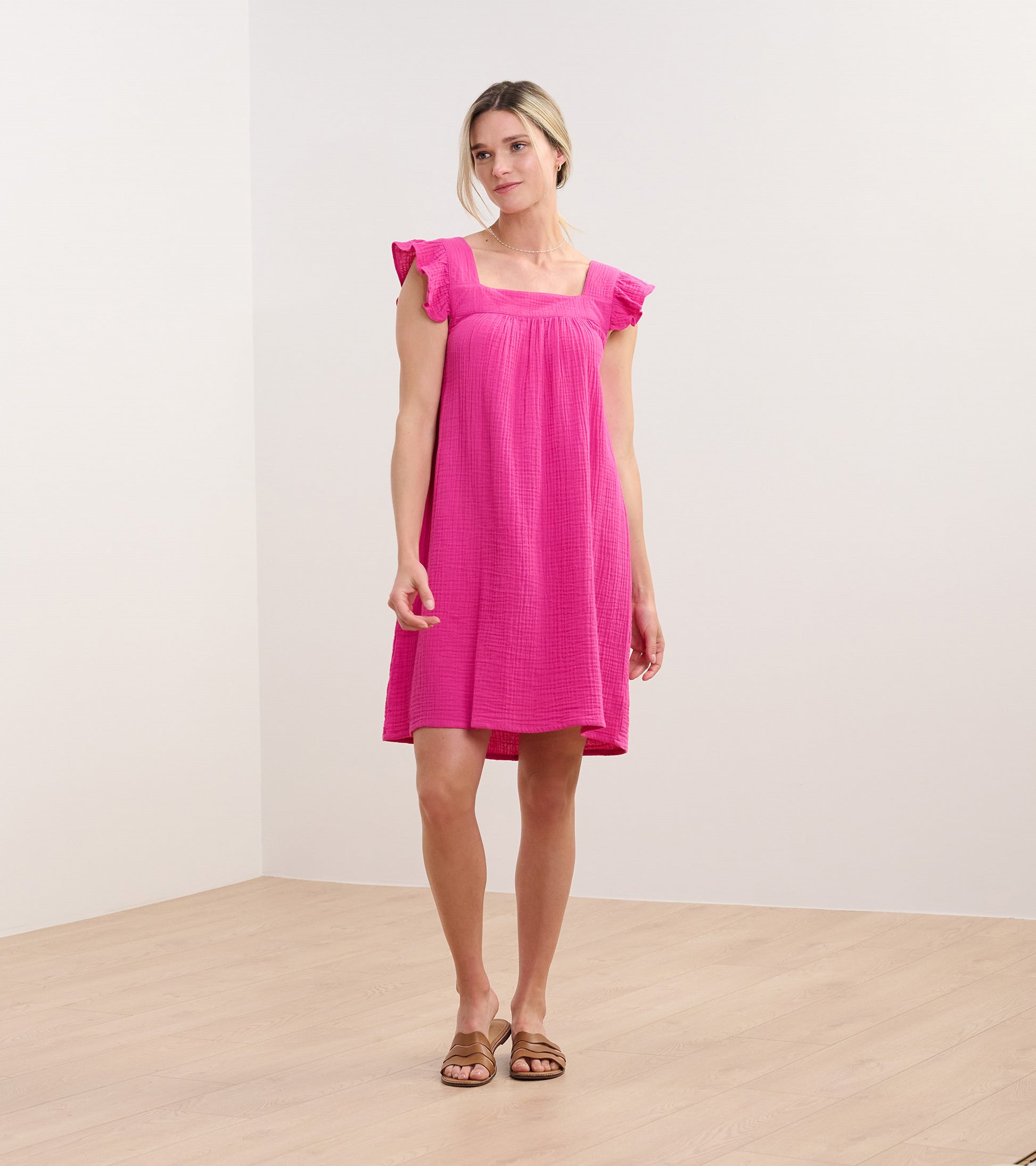 Fuchsia flutter sleeve dress with a square neckline, relaxed fit, and knee-length hem, styled with sandals.