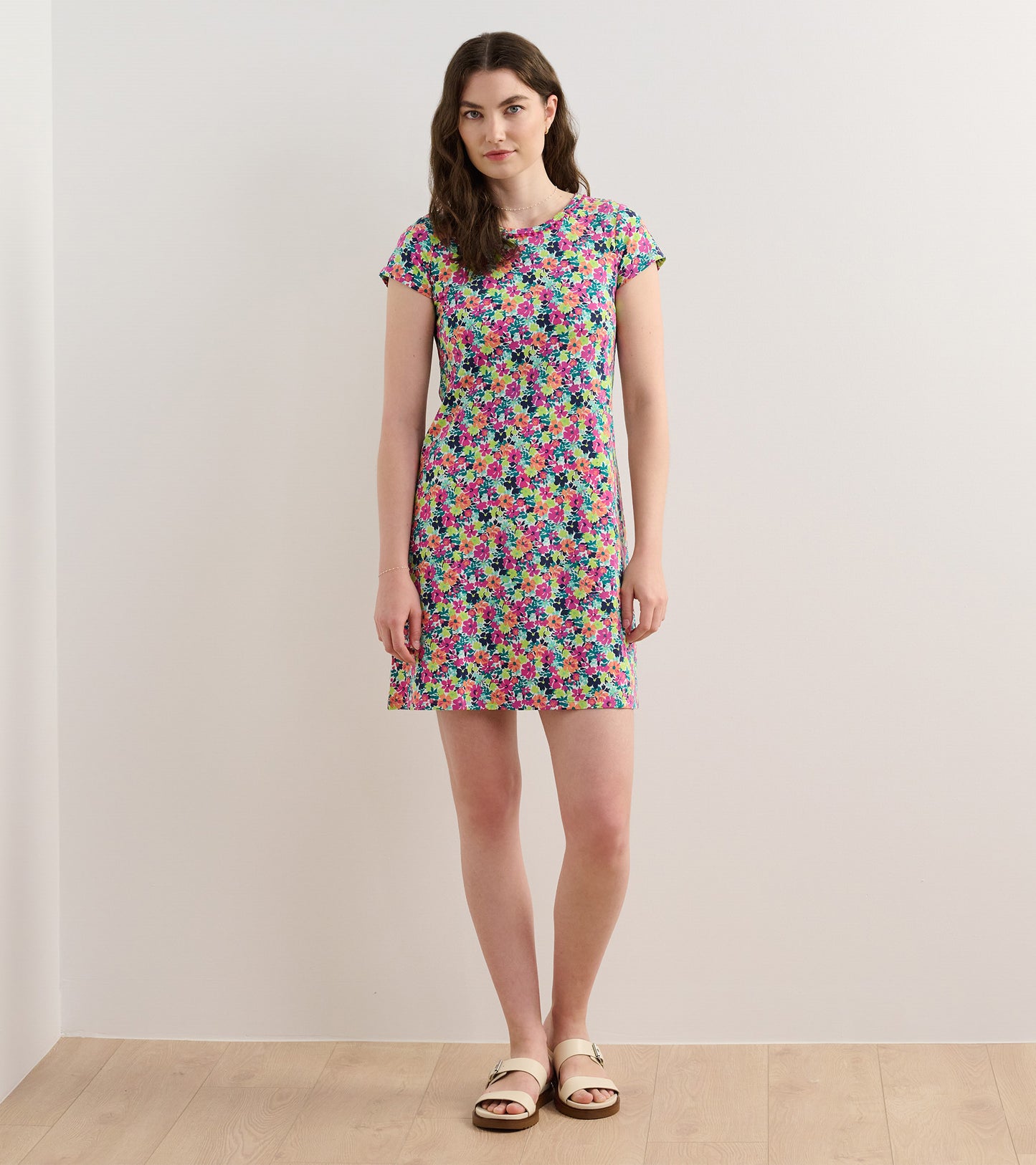 Short-sleeve A-line dress featuring a vibrant floral pattern in pink, purple, and green on a light background.
