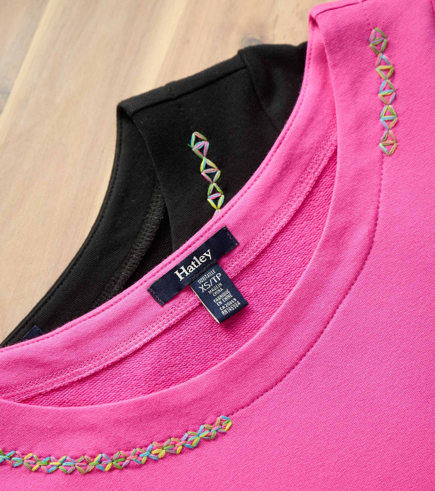 Fuchsia French terry dress with colorful embroidery detail on the neckline, featuring a round collar and soft fabric.