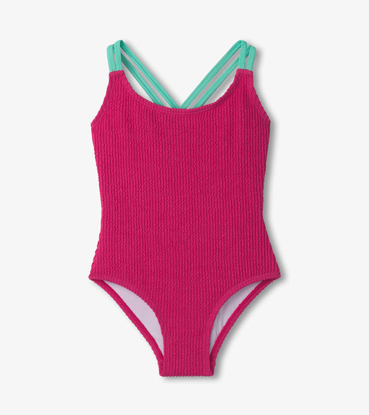Fuchsia purple cross strap swimsuit with textured fabric and contrasting mint green straps.