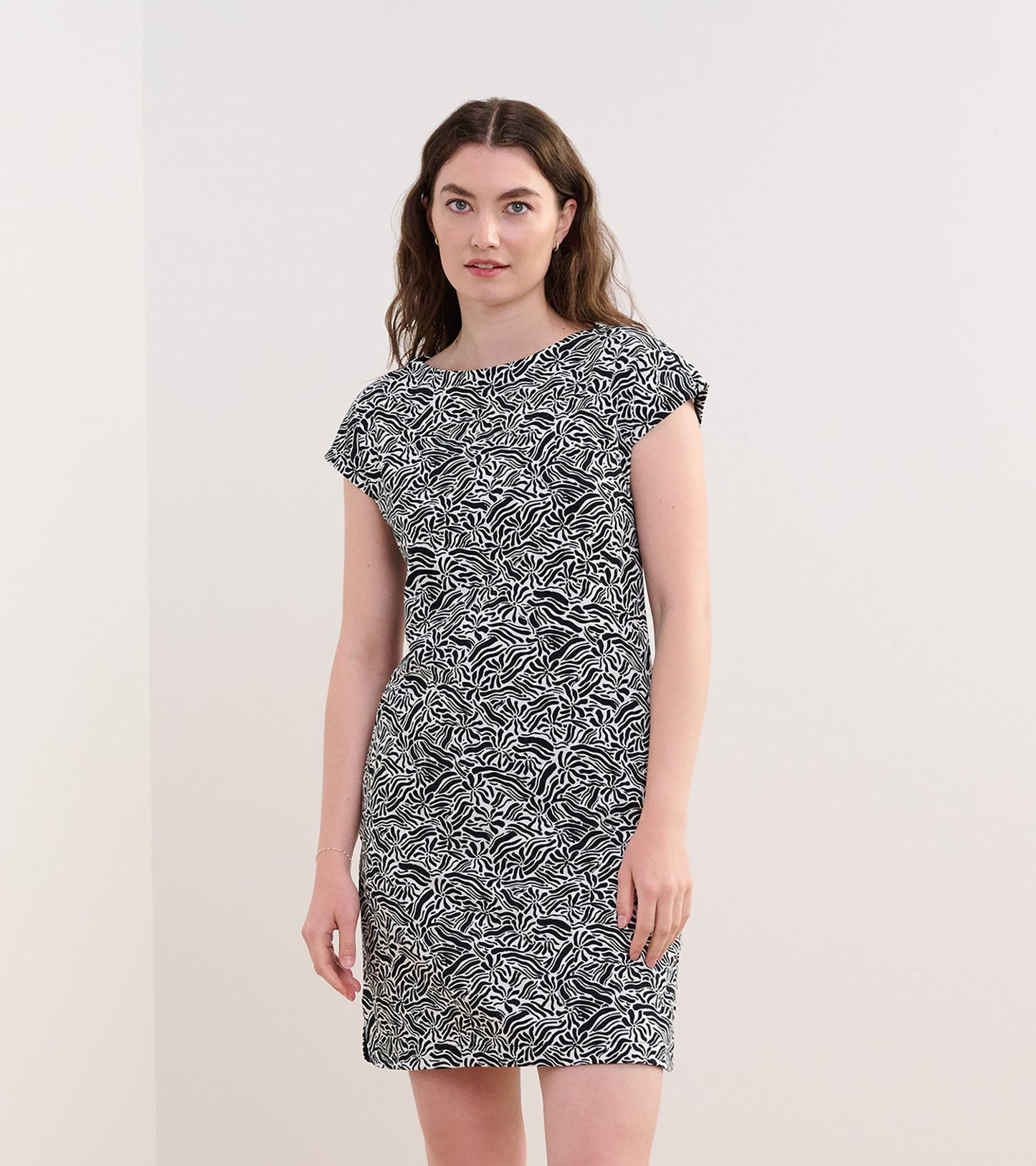Short-sleeve dress featuring a black and white groovy floral pattern, fitted silhouette, and round neckline.