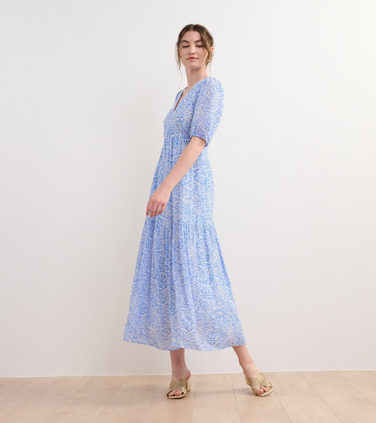 Light blue maxi dress with a floral pattern, featuring short puff sleeves and a fitted bodice.