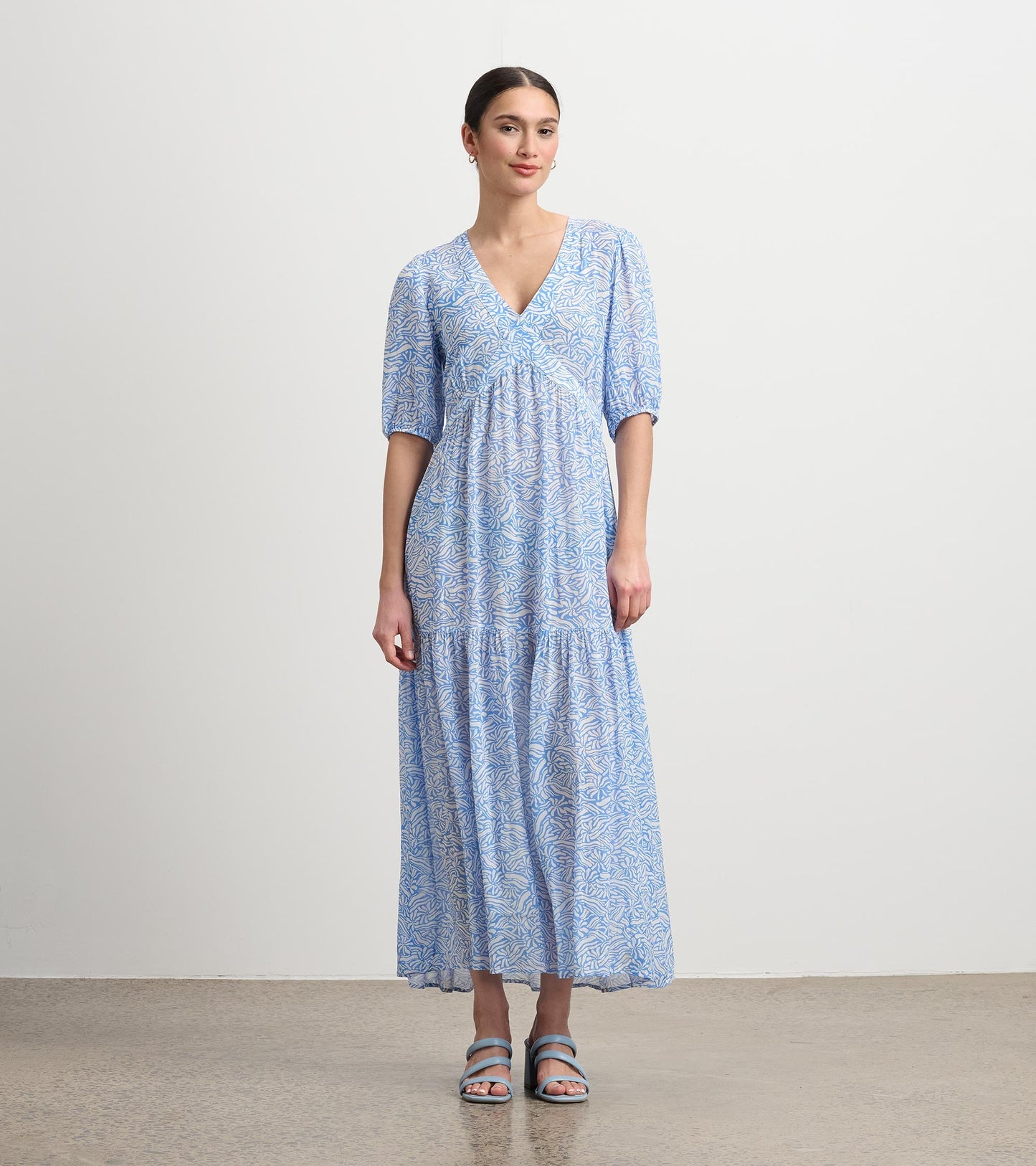 Light blue maxi dress with a floral pattern, v-neckline, and short puff sleeves. Ideal for casual summer outings.