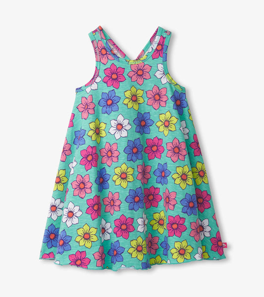 Trapeze dress featuring a vibrant floral pattern in pink, yellow, and blue on a teal background.