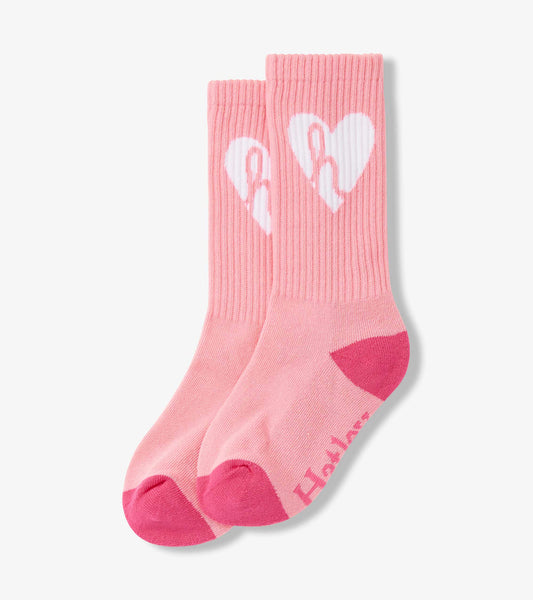 Pink ribbed tube socks featuring a white heart design and contrasting pink toe and heel. Suitable for ages 2-12.