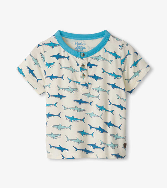 Bamboo henley shirt for baby boys featuring a playful shark pattern in blue on a cream background. Short sleeves and button…