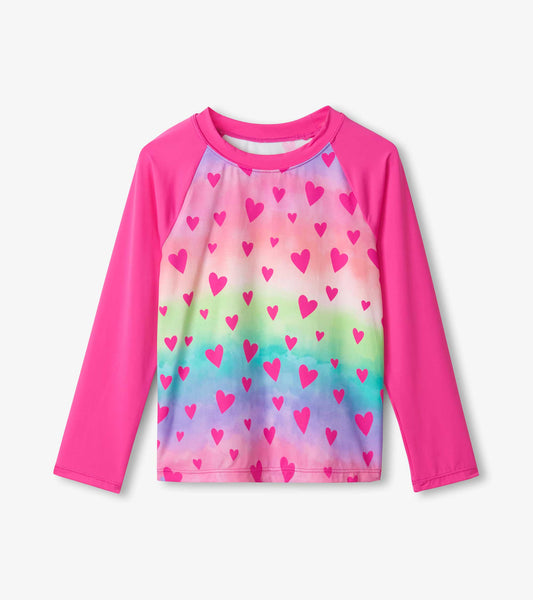 Long sleeve rashguard featuring a colorful heart pattern on a gradient background with pink sleeves.