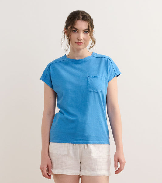 Blue slouchy pocket tee with short sleeves and a relaxed fit, paired with white shorts.
