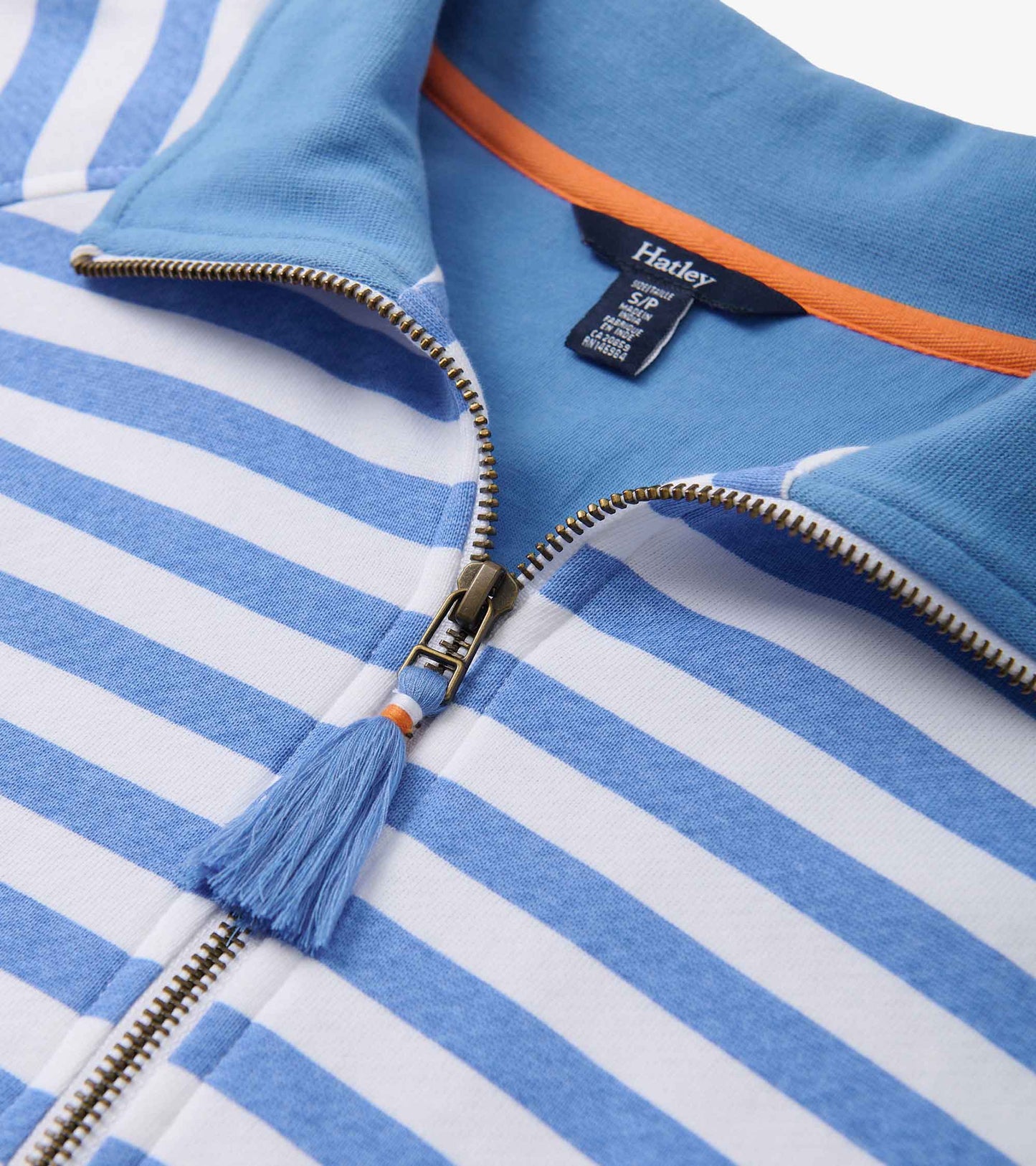 Mock neck pullover featuring blue and white stripes, with a zip closure and tassel detail at the zipper.