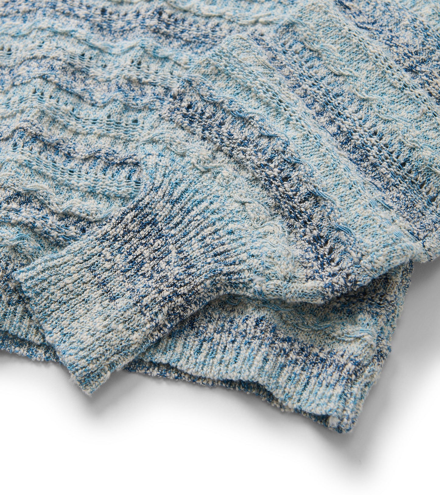Light blue pointelle sweater featuring wavy stripes and textured knit, showcasing a cozy and stylish design.