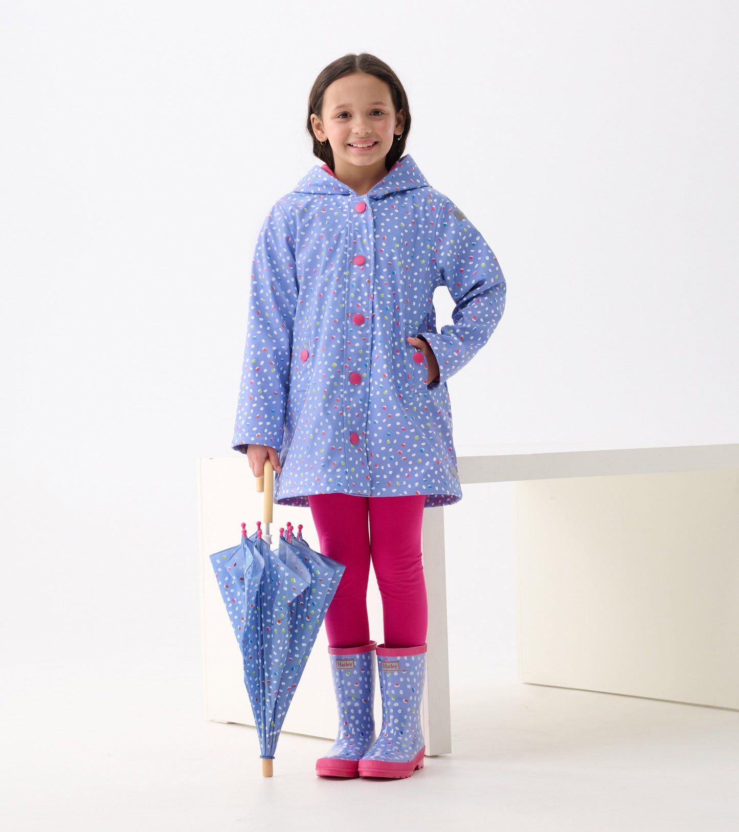 Shiny blue rain boots with colorful dots and pink soles, perfect for kids on rainy days.