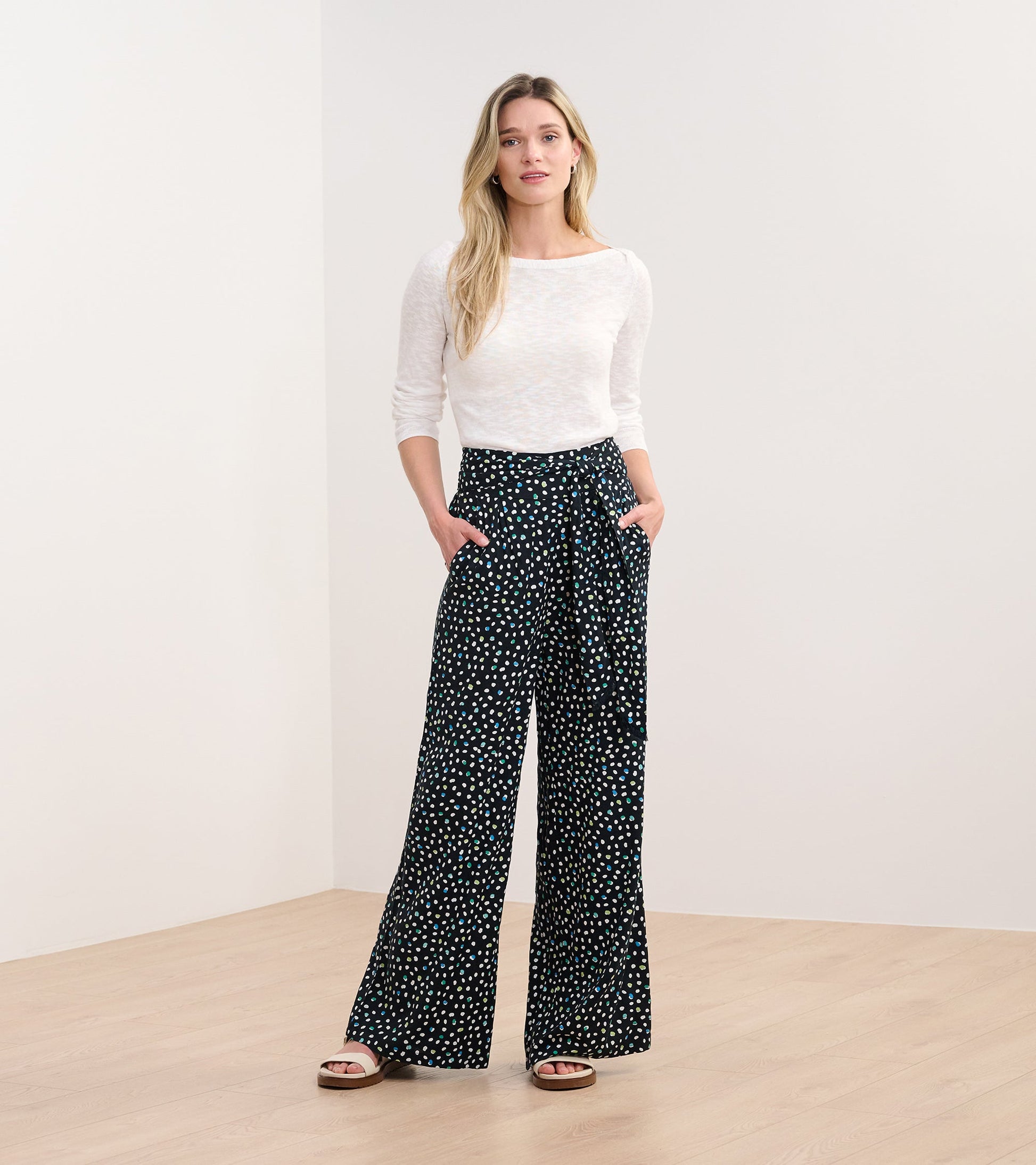 Belted wide leg pants in black with a multi-colored dot pattern, featuring side pockets and a relaxed fit.