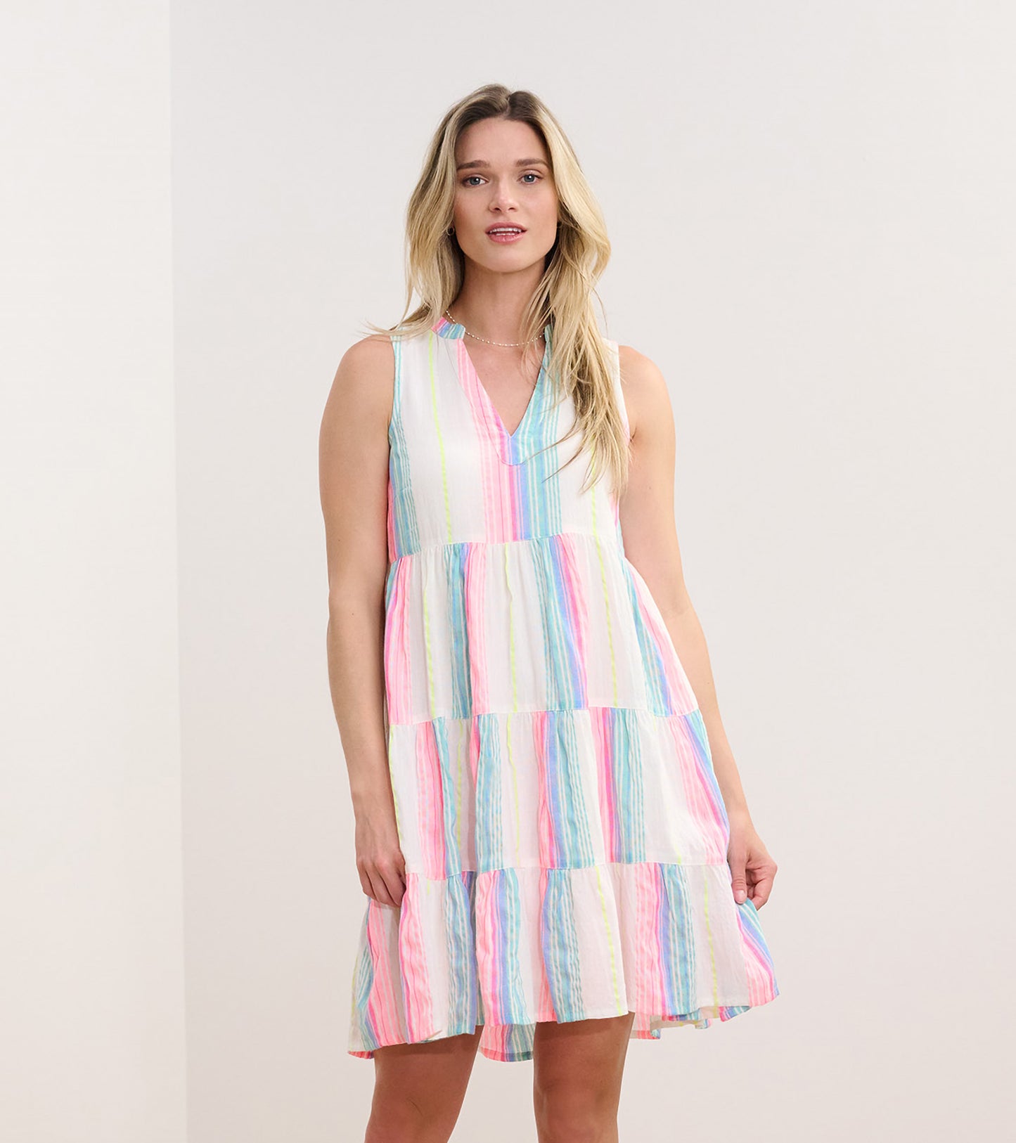 Sleeveless dress featuring neon bright stripes in pink, blue, and green with a tiered skirt design.