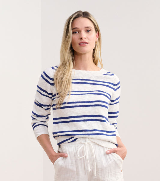 Navy and white striped sweater with a relaxed fit and long sleeves, styled with light-colored pants.