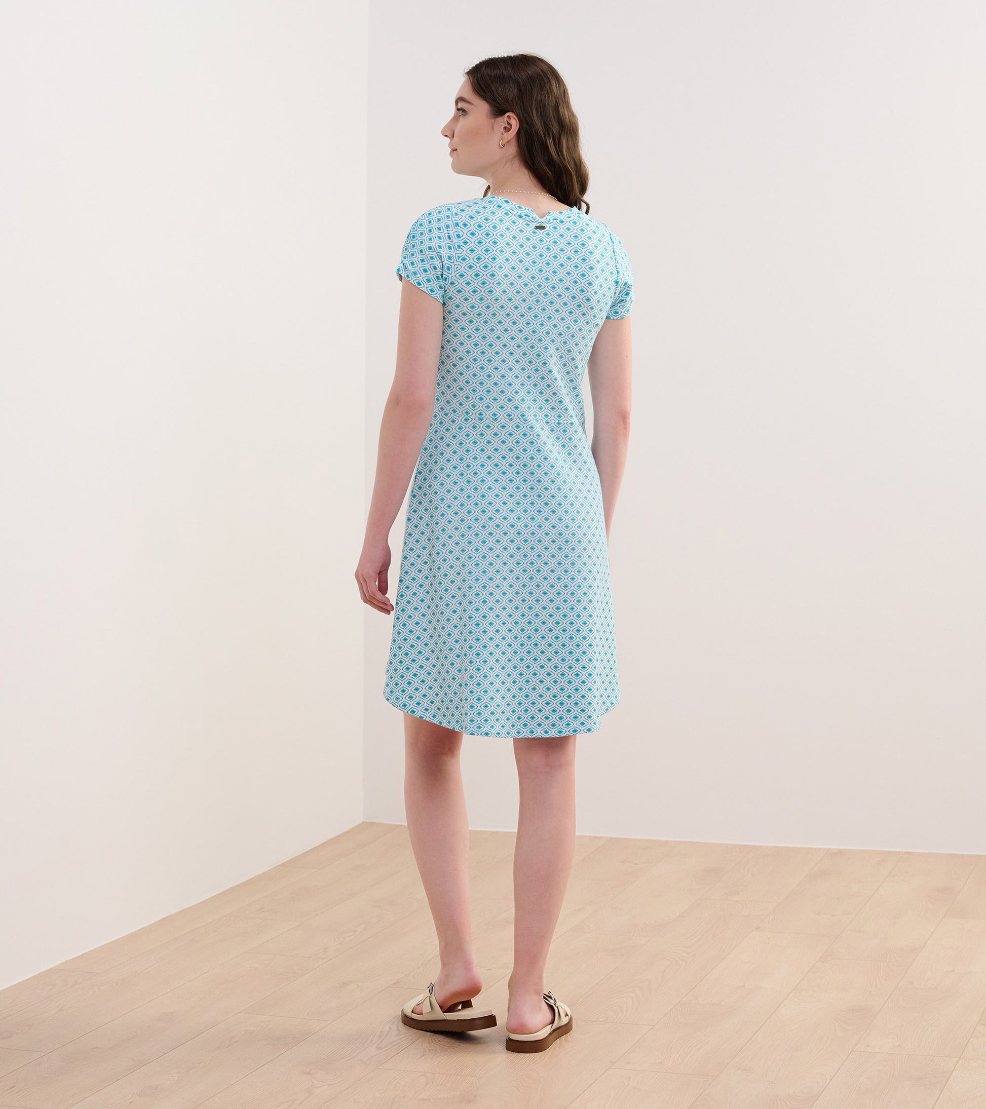 Light blue dress with a painted petal pattern, short sleeves, and a relaxed fit, shown from the back.