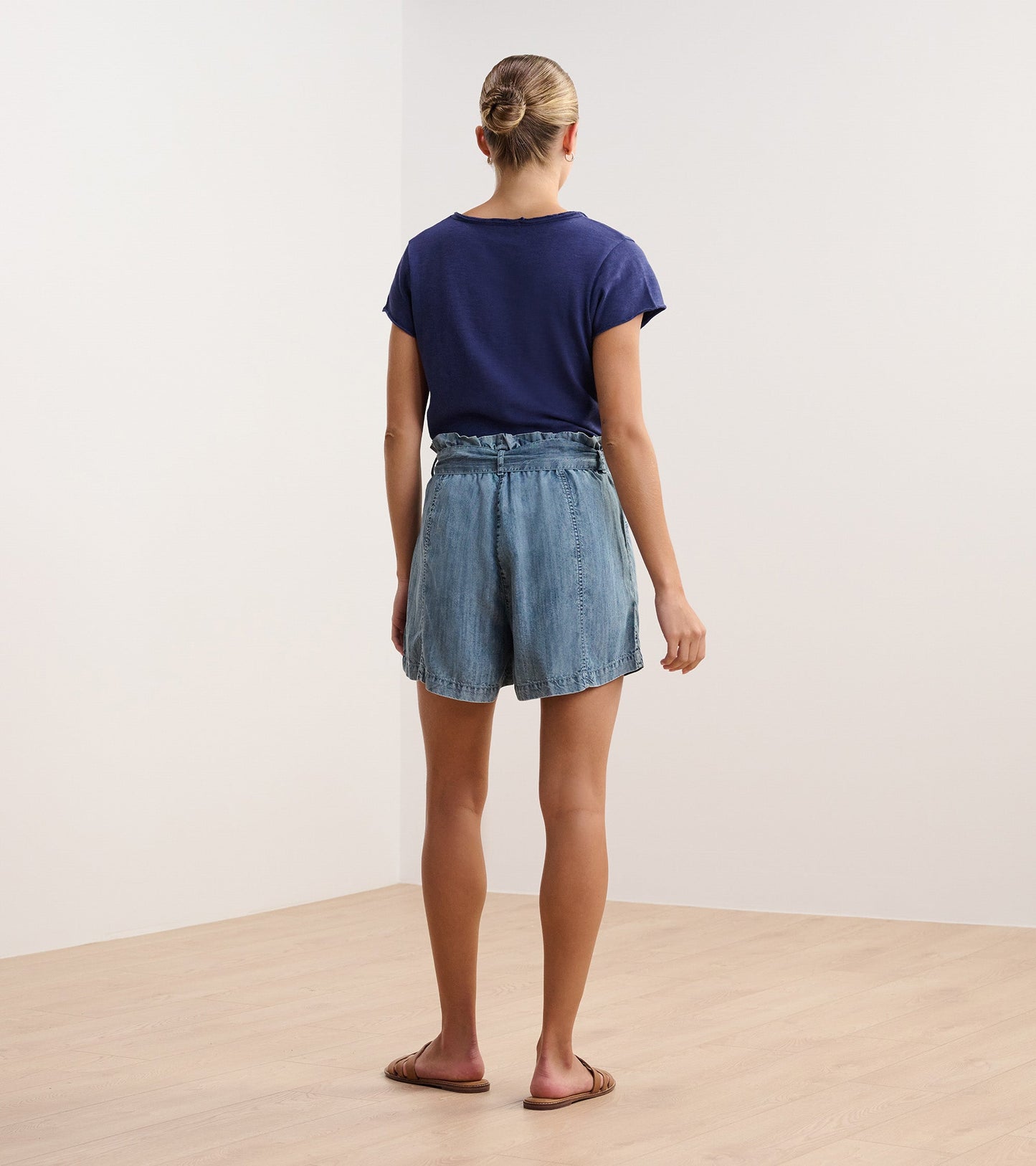 Patriot blue V-neck tee with short sleeves, worn with light denim shorts, viewed from the back.