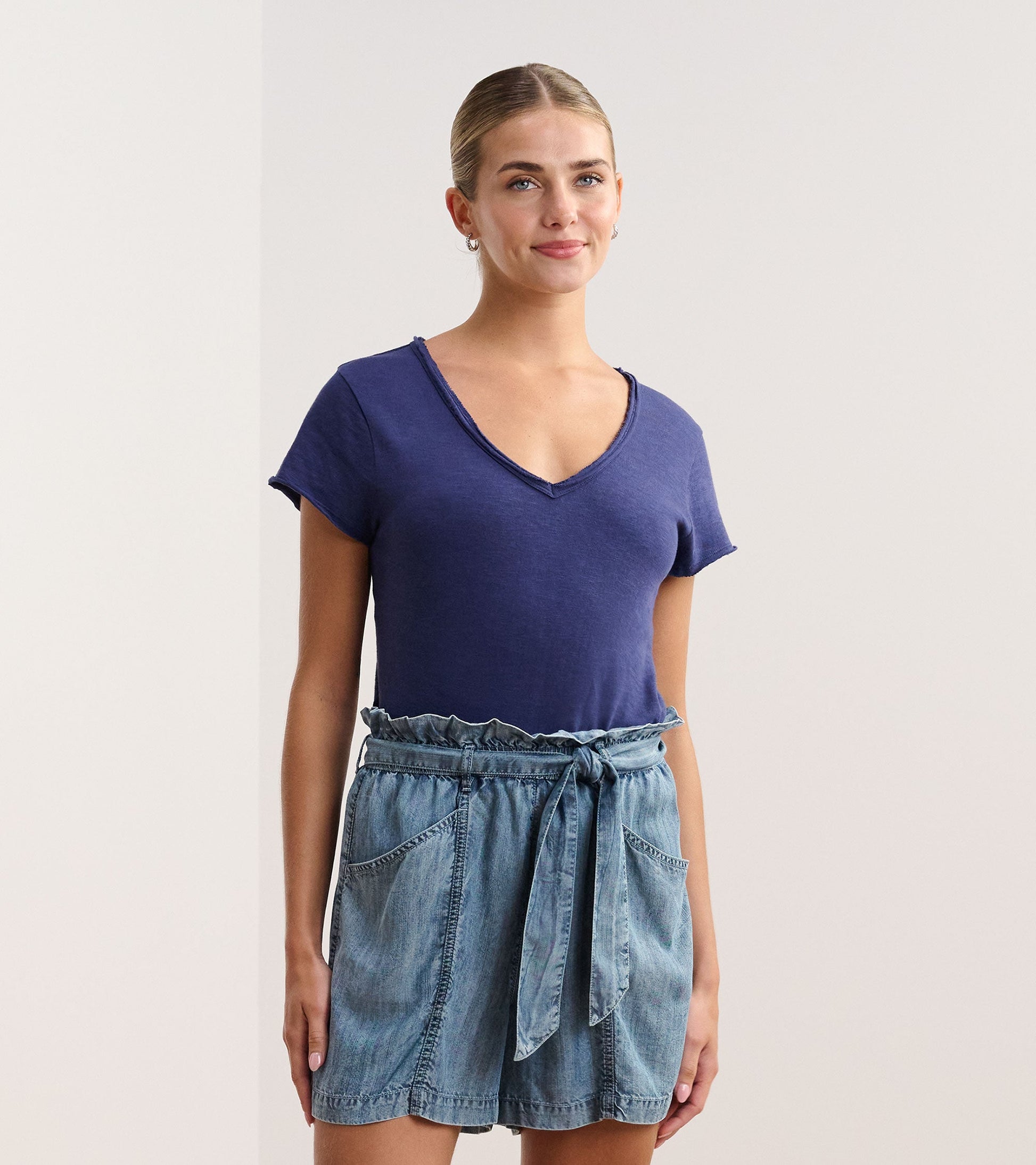 Patriot blue V-neck tee with short sleeves, paired with a denim skirt featuring a tied waist.