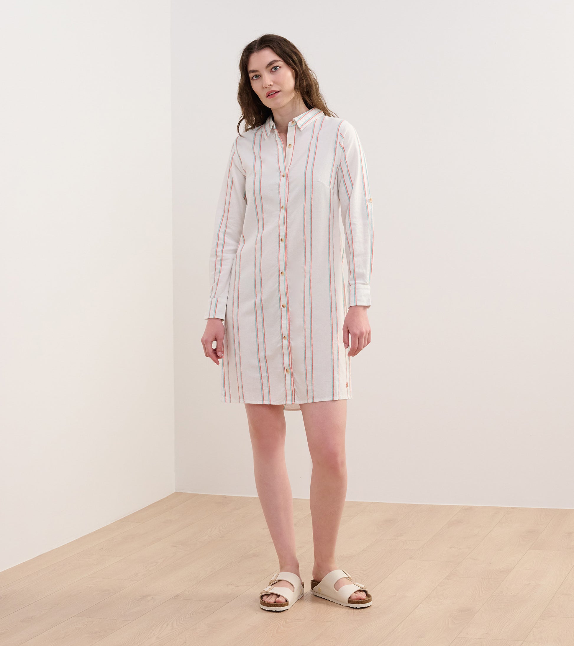 Peach and white striped shirt dress with long sleeves and button front, styled with sandals.