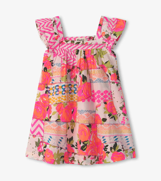 Floral patchwork dress with flutter sleeves in vibrant pink, orange, and green hues, perfect for warm weather.