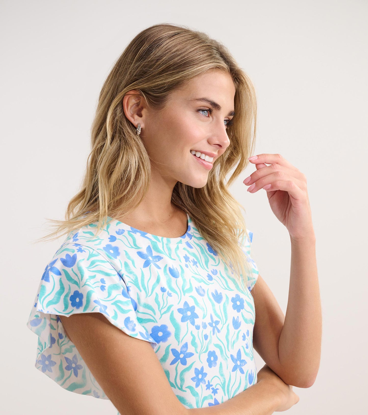 Short-sleeve dress featuring a light blue background with painted floral patterns in blue and green tones.