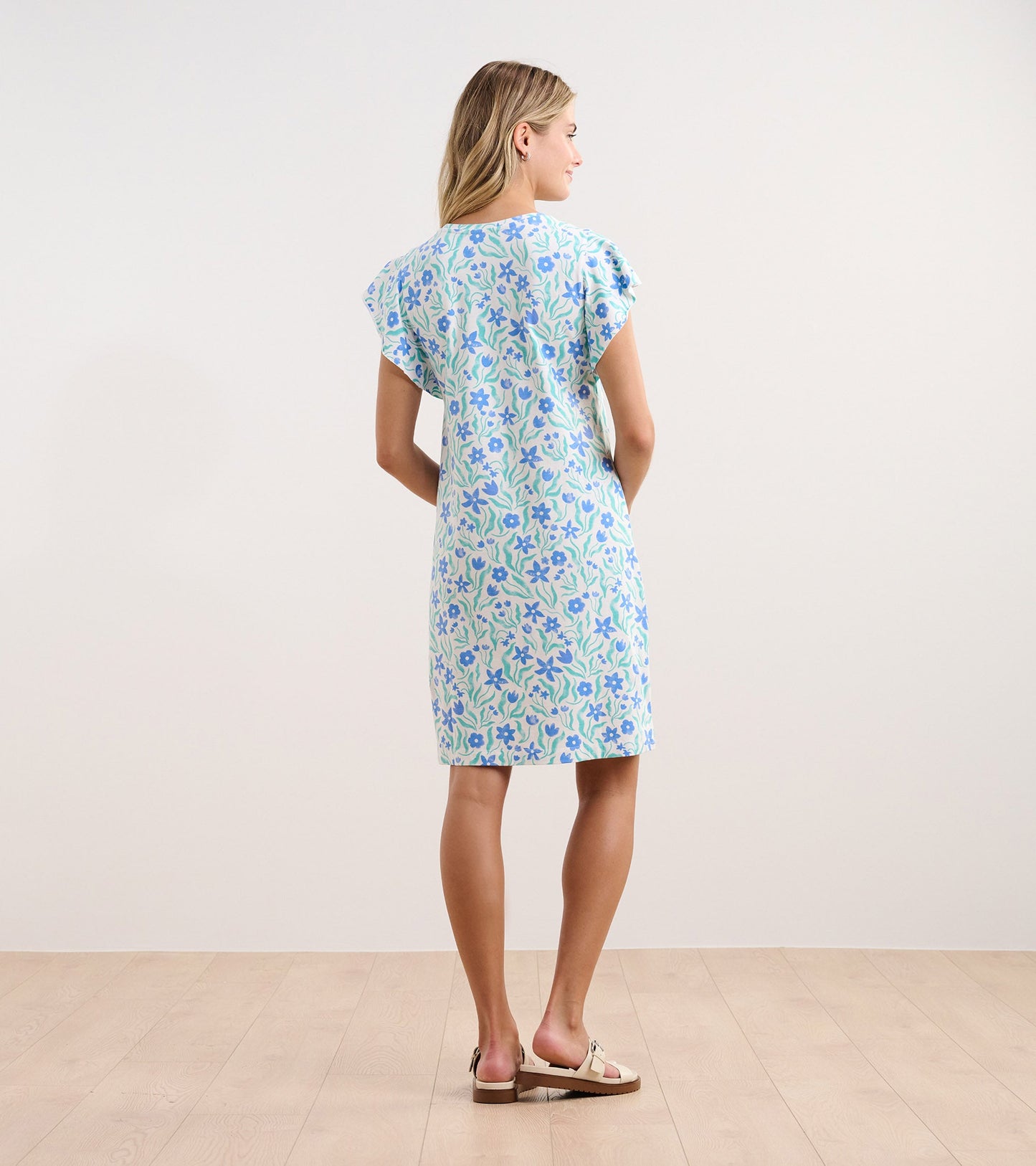 Light blue dress with a painted floral pattern, short sleeves, and a relaxed fit, shown from the back.