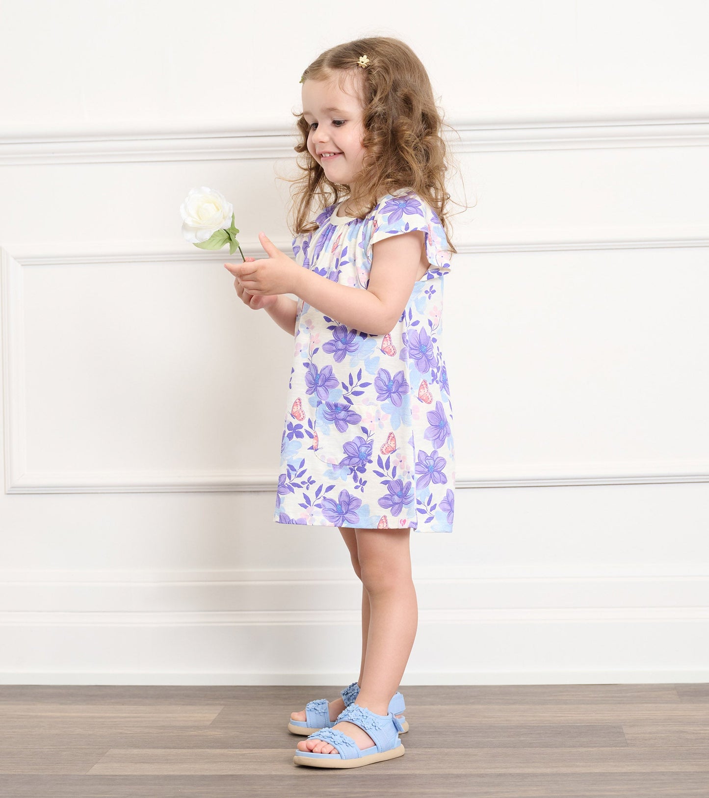 Light purple dress with floral pattern, short sleeves, and a relaxed fit, worn by a girl holding a flower.
