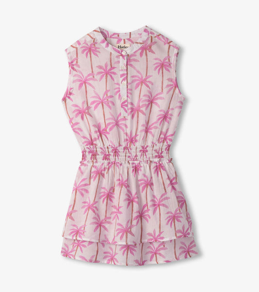 Light pink dress with palm tree print, smocked waist, and sleeveless design.