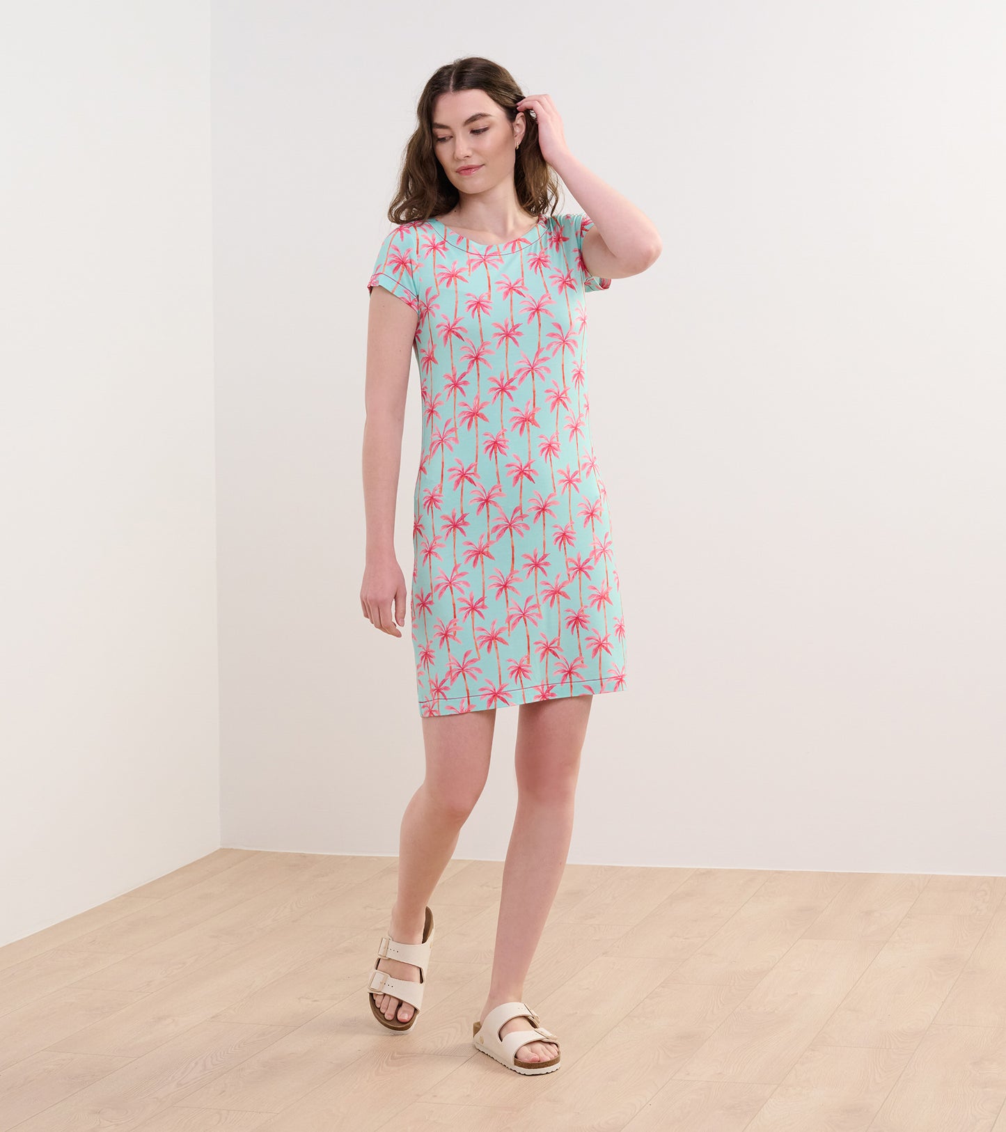 Short-sleeve dress featuring a light blue background with pink palm tree print, ideal for casual summer wear.