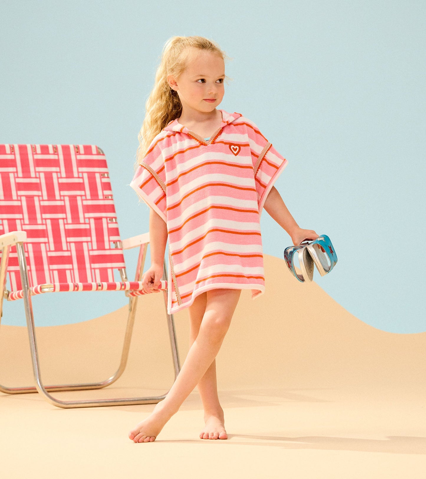 Pink striped hooded cover-up with short sleeves, perfect for beachwear, worn by a girl holding flip-flops.