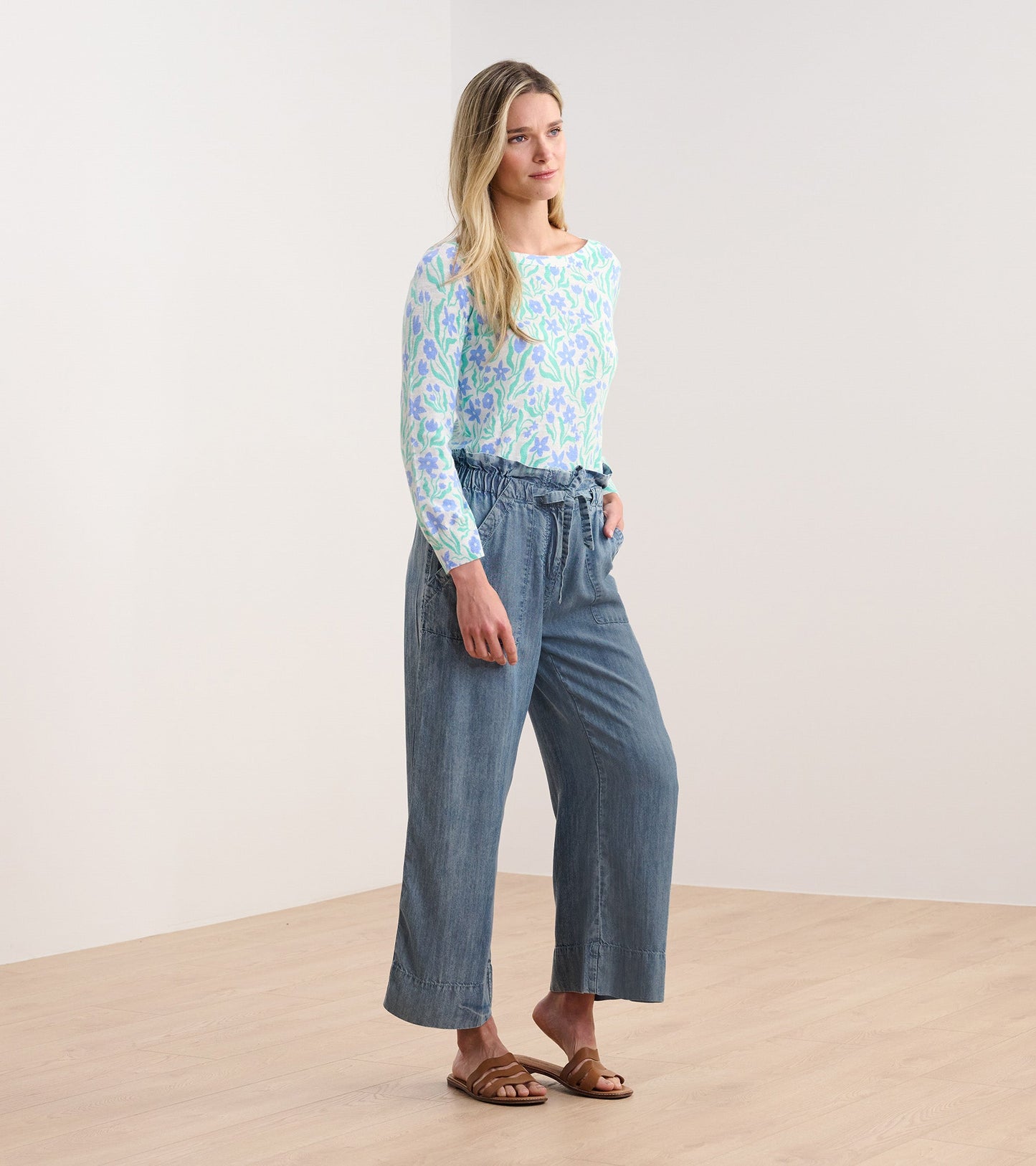 Light blue 3/4 sleeve knit top with painted floral pattern, paired with loose denim pants and sandals.