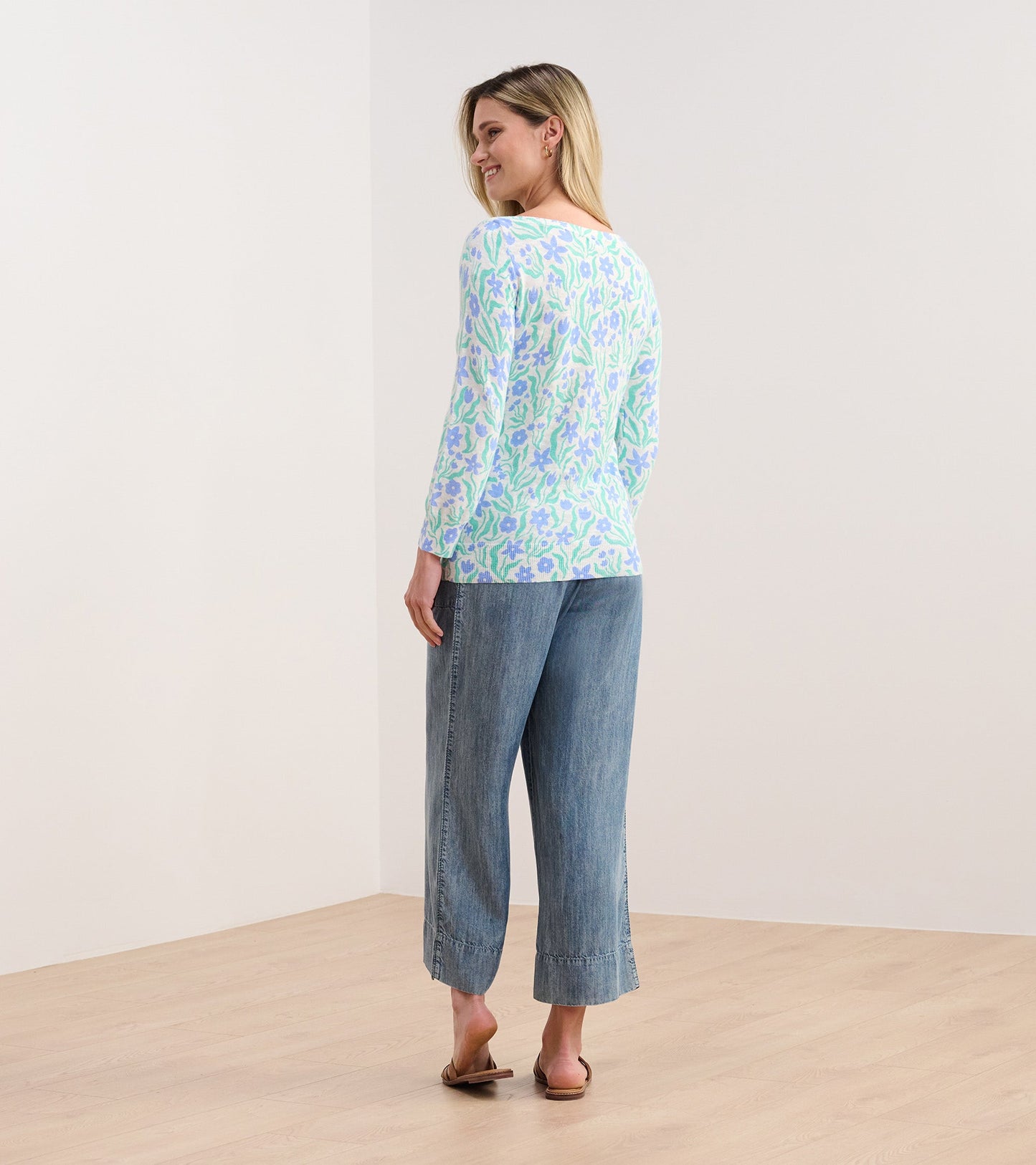 Lightweight knit top with 3/4 sleeves, featuring a painted floral pattern in pastel colors, worn with wide-leg jeans.