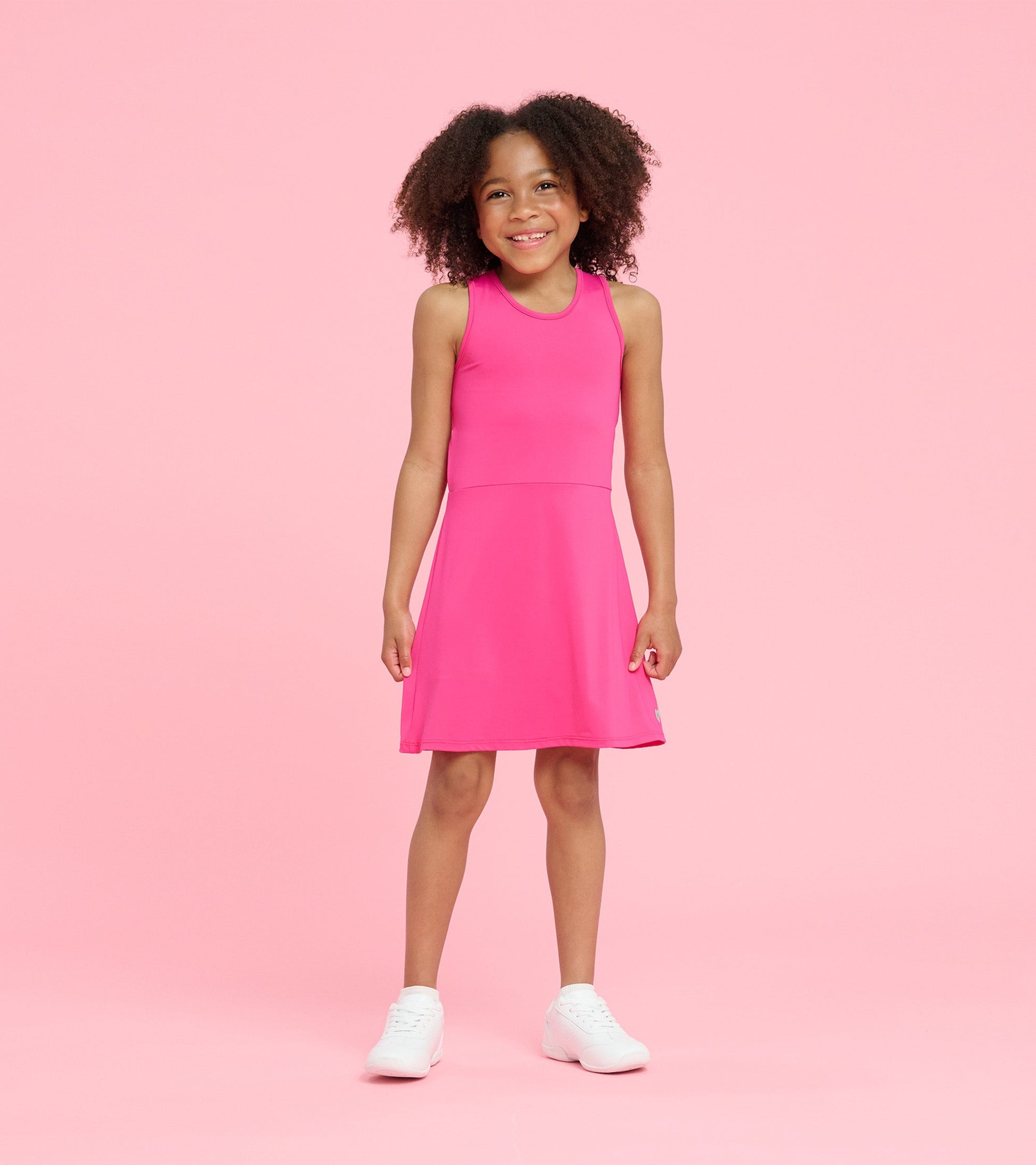Bright pink A-line dress with a sleeveless design, perfect for active play, worn by a smiling girl.