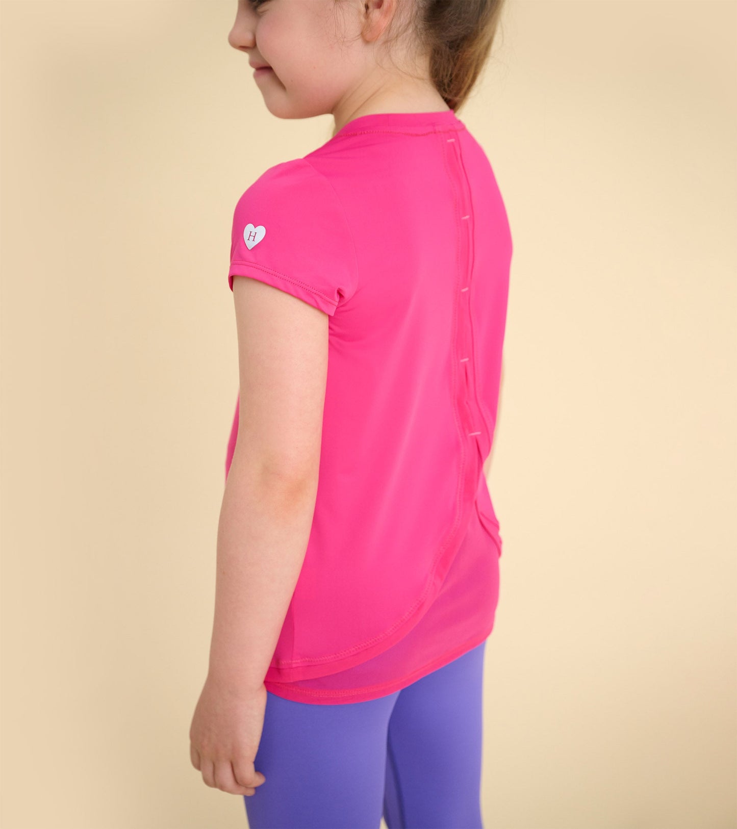 Bright pink short-sleeve T-shirt with mesh trim and button detail at the back, perfect for casual wear.